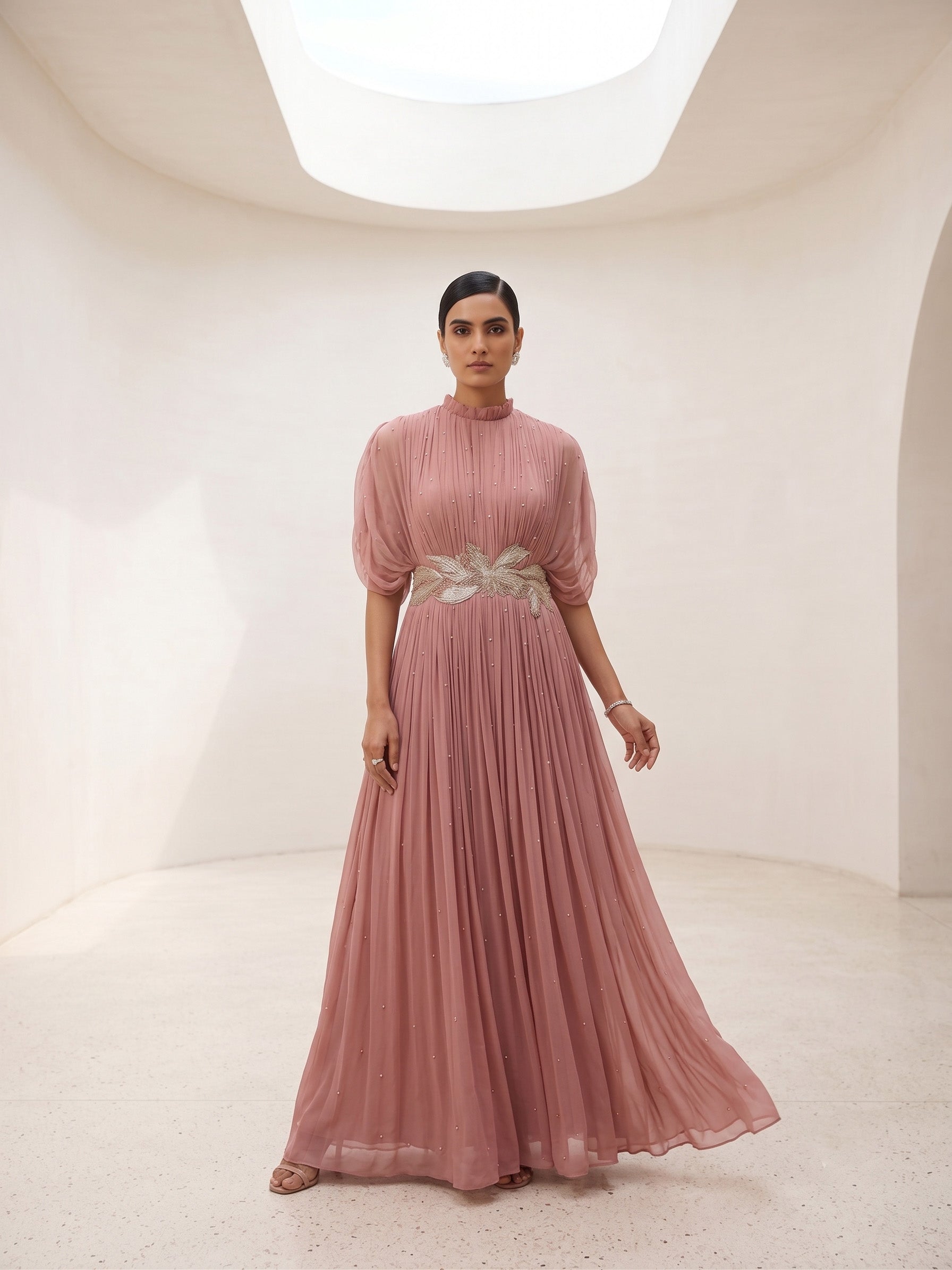 DUSTY ROSE SEQUIN AND WIRE EMBELLISHED PLEATED GOWN WITH SHEER SLEEVES.