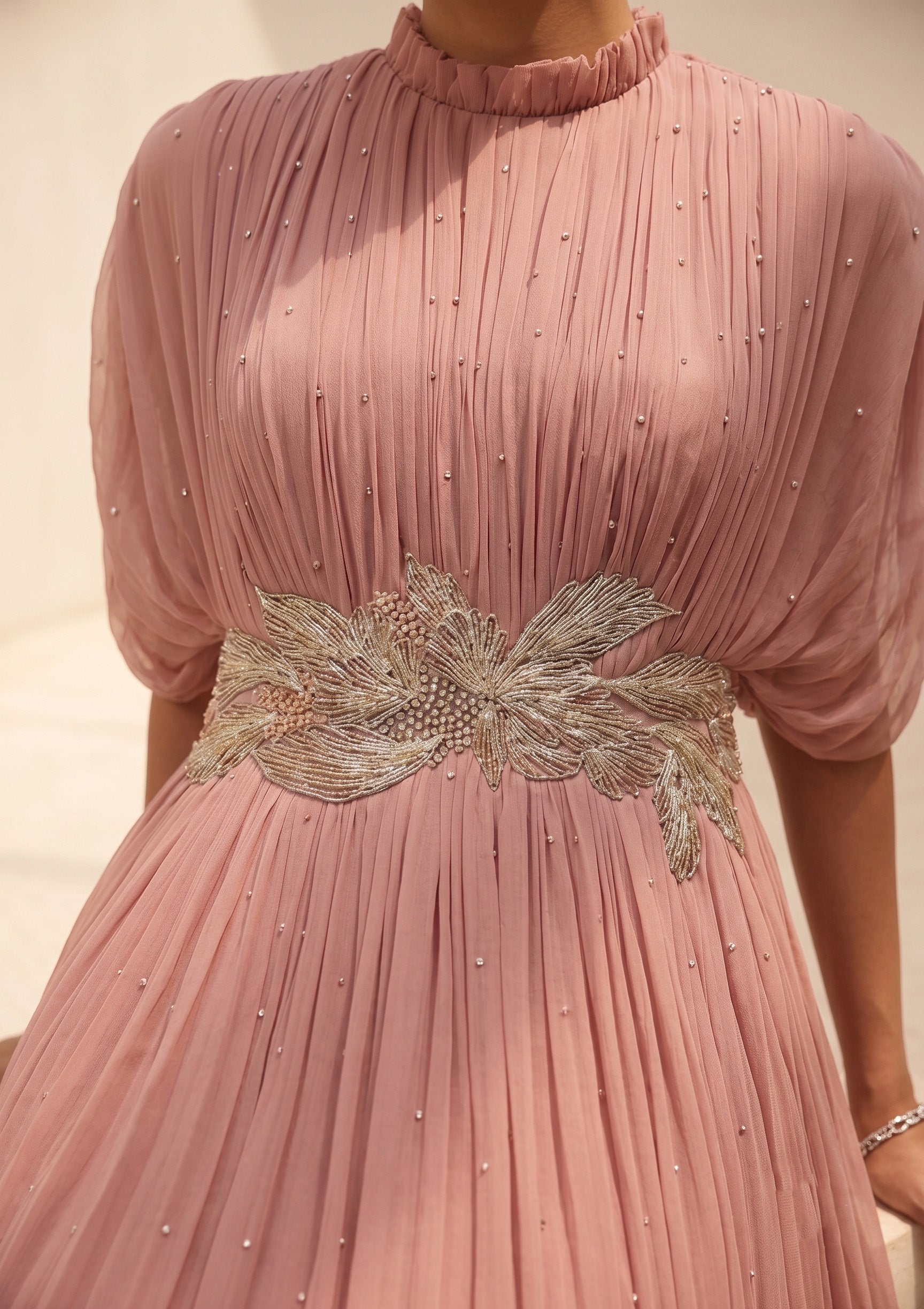 DUSTY ROSE SEQUIN AND WIRE EMBELLISHED PLEATED GOWN WITH SHEER SLEEVES.