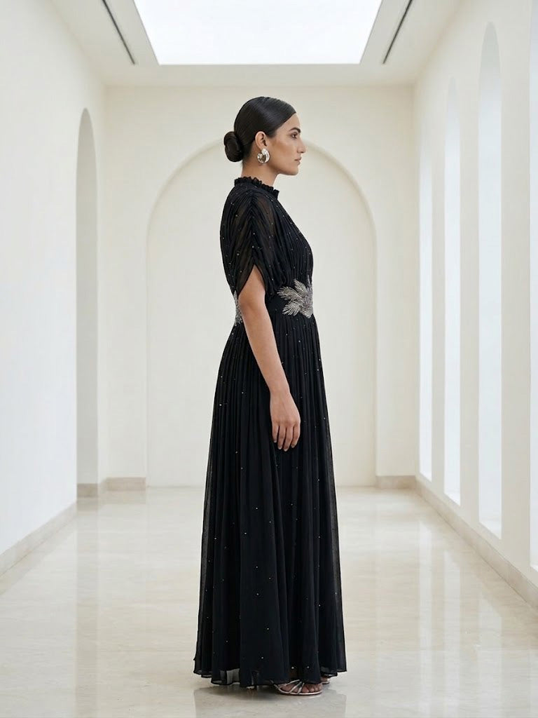 BLACK SEQUIN AND WIRE EMBELLISHED PLEATED GOWN WITH SHEER SLEEVES.
