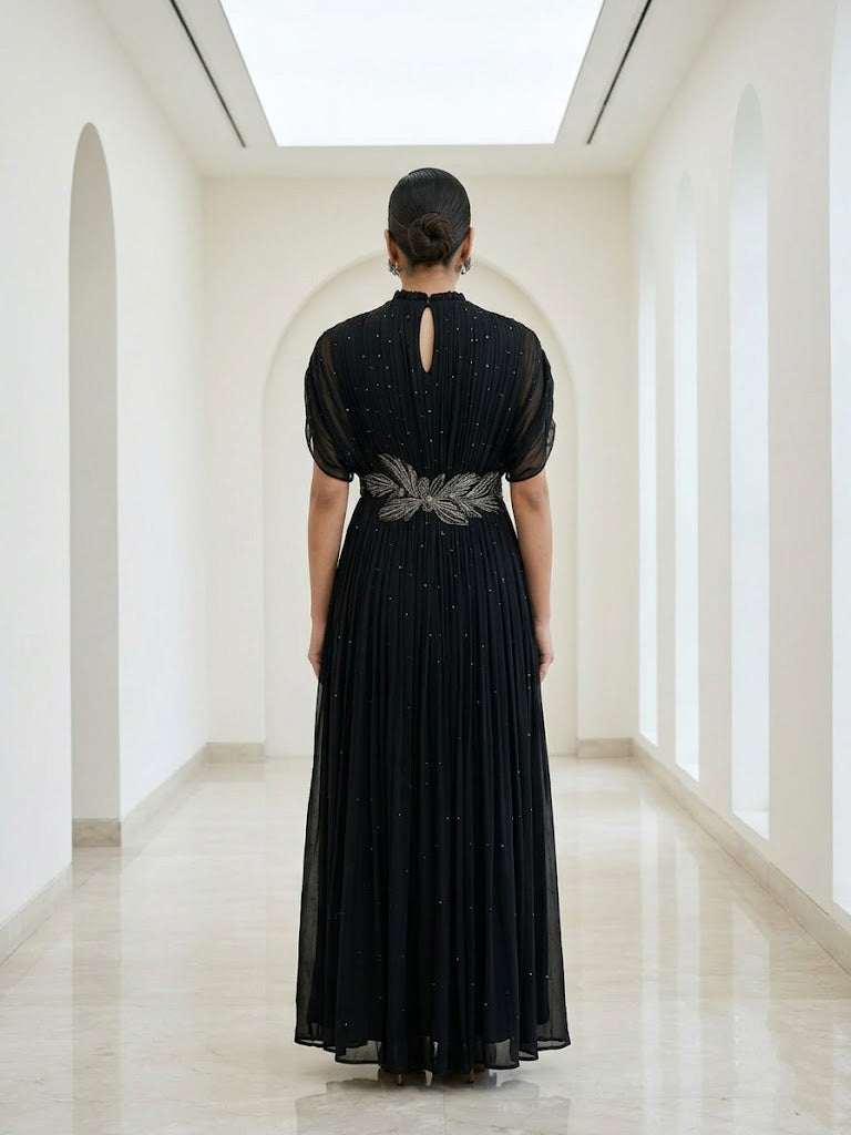 BLACK SEQUIN AND WIRE EMBELLISHED PLEATED GOWN WITH SHEER SLEEVES.