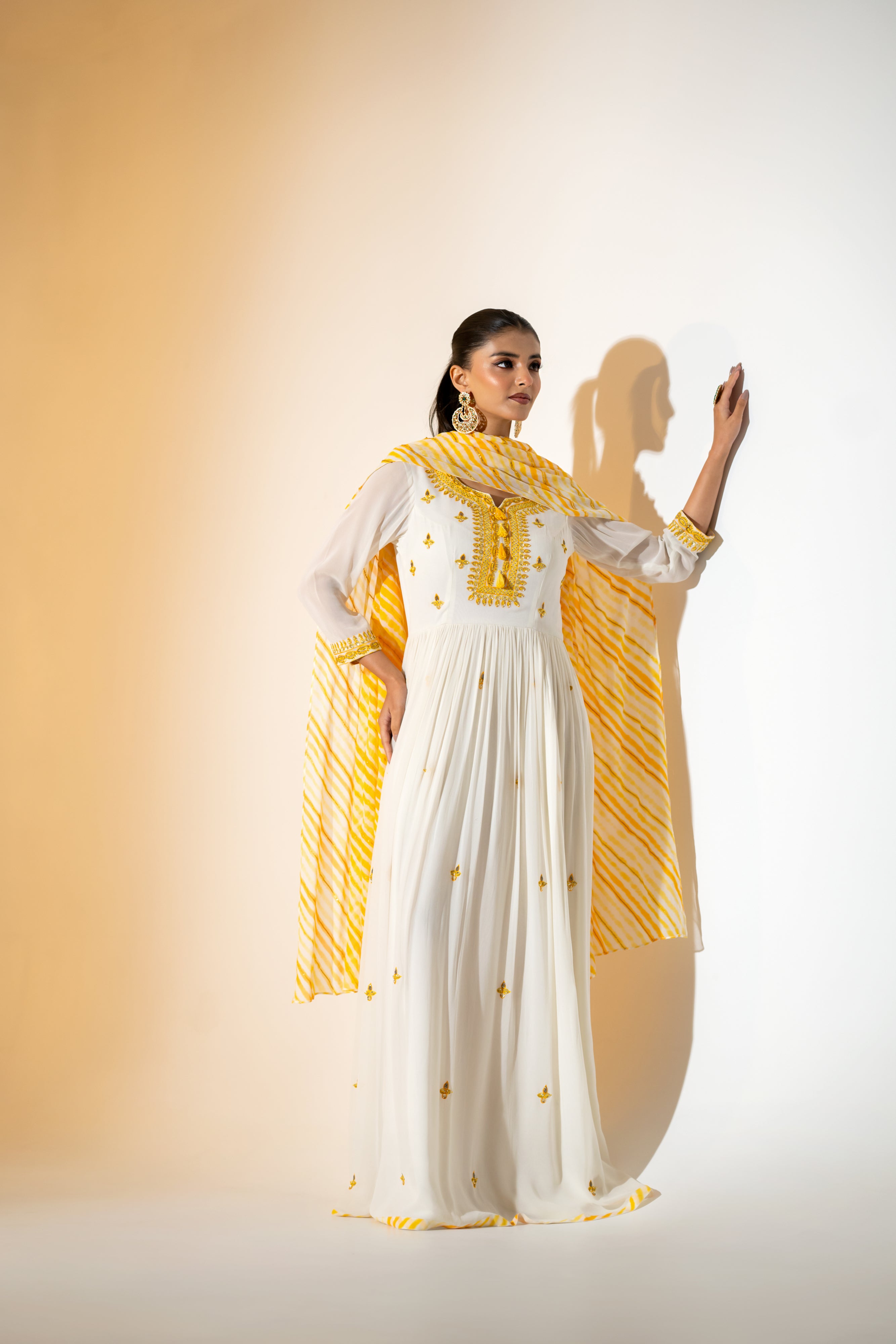 OFF- WHITE  ANARKALI WITH AN EMBROIDERED BODICE AND YELLOW TONE LEHERIYA DUPATTA .