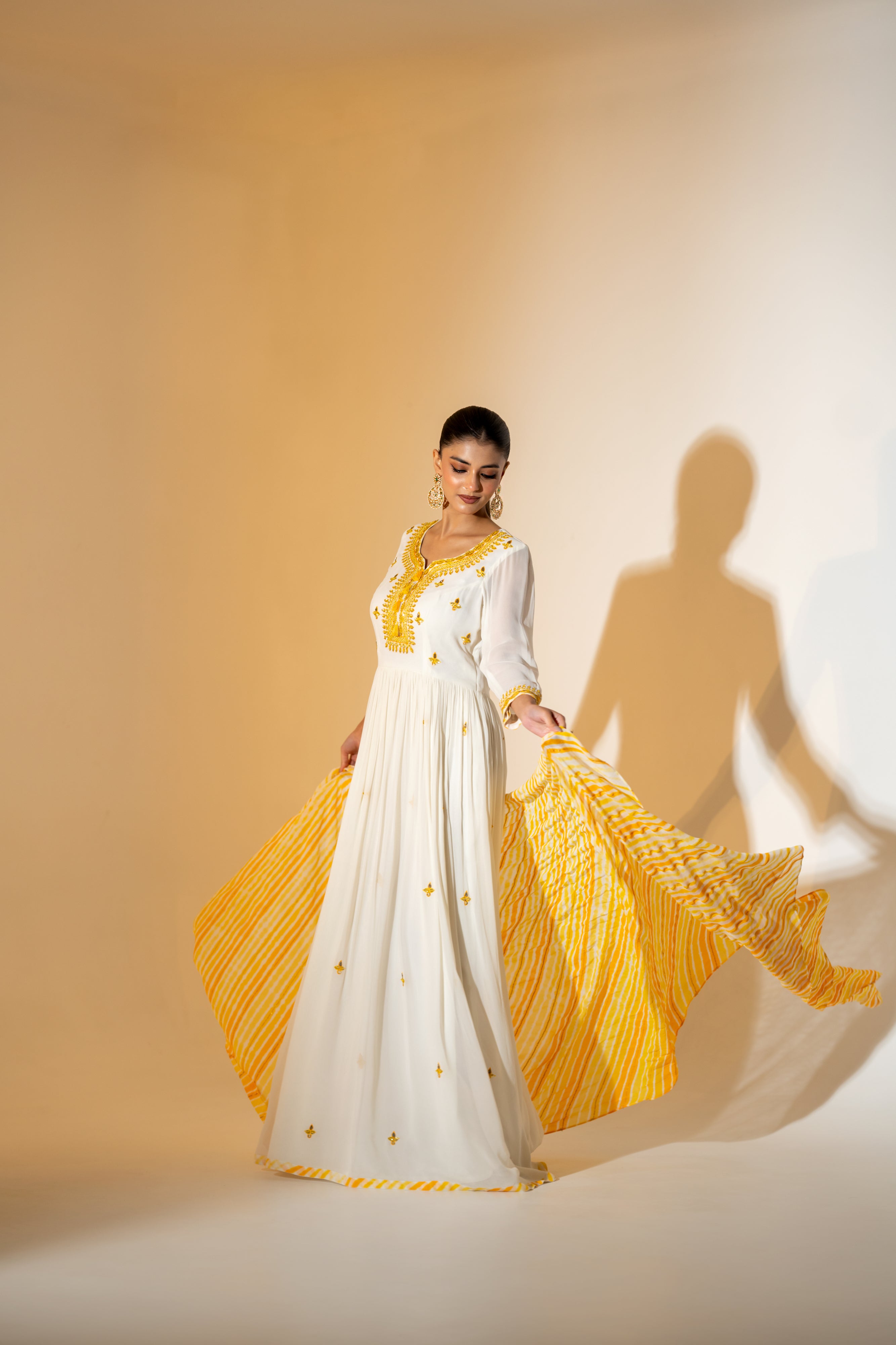 OFF- WHITE  ANARKALI WITH AN EMBROIDERED BODICE AND YELLOW TONE LEHERIYA DUPATTA .
