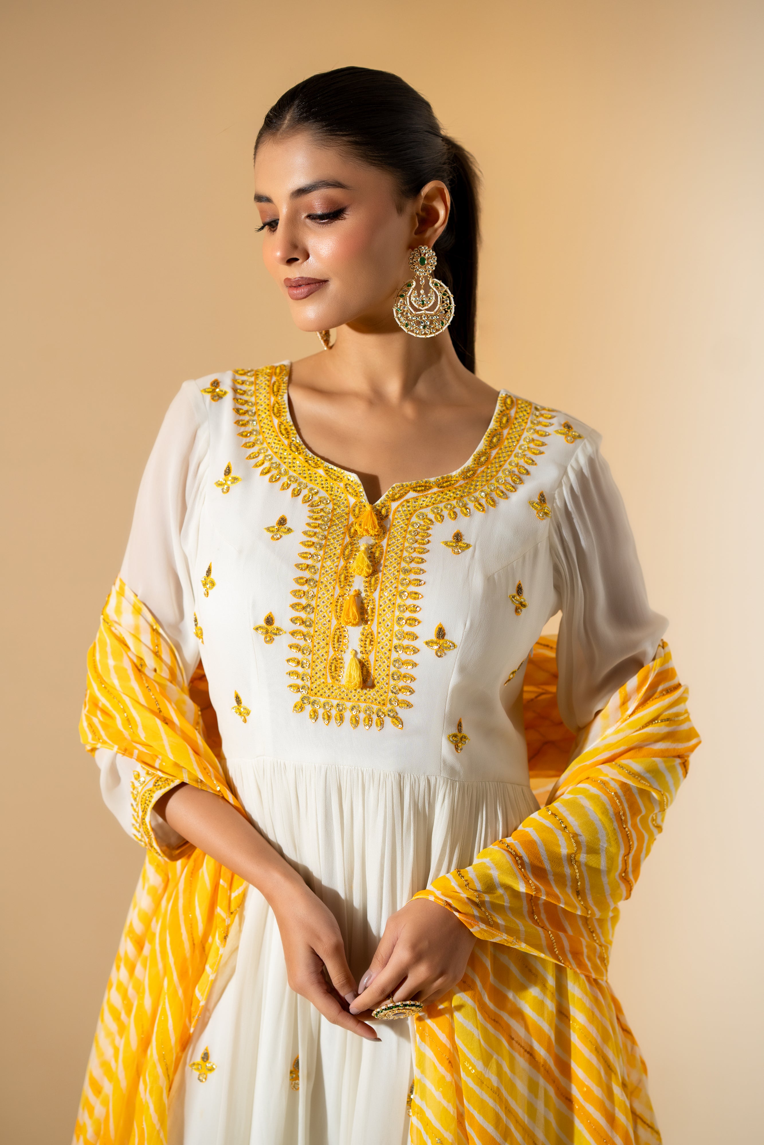 OFF- WHITE  ANARKALI WITH AN EMBROIDERED BODICE AND YELLOW TONE LEHERIYA DUPATTA .