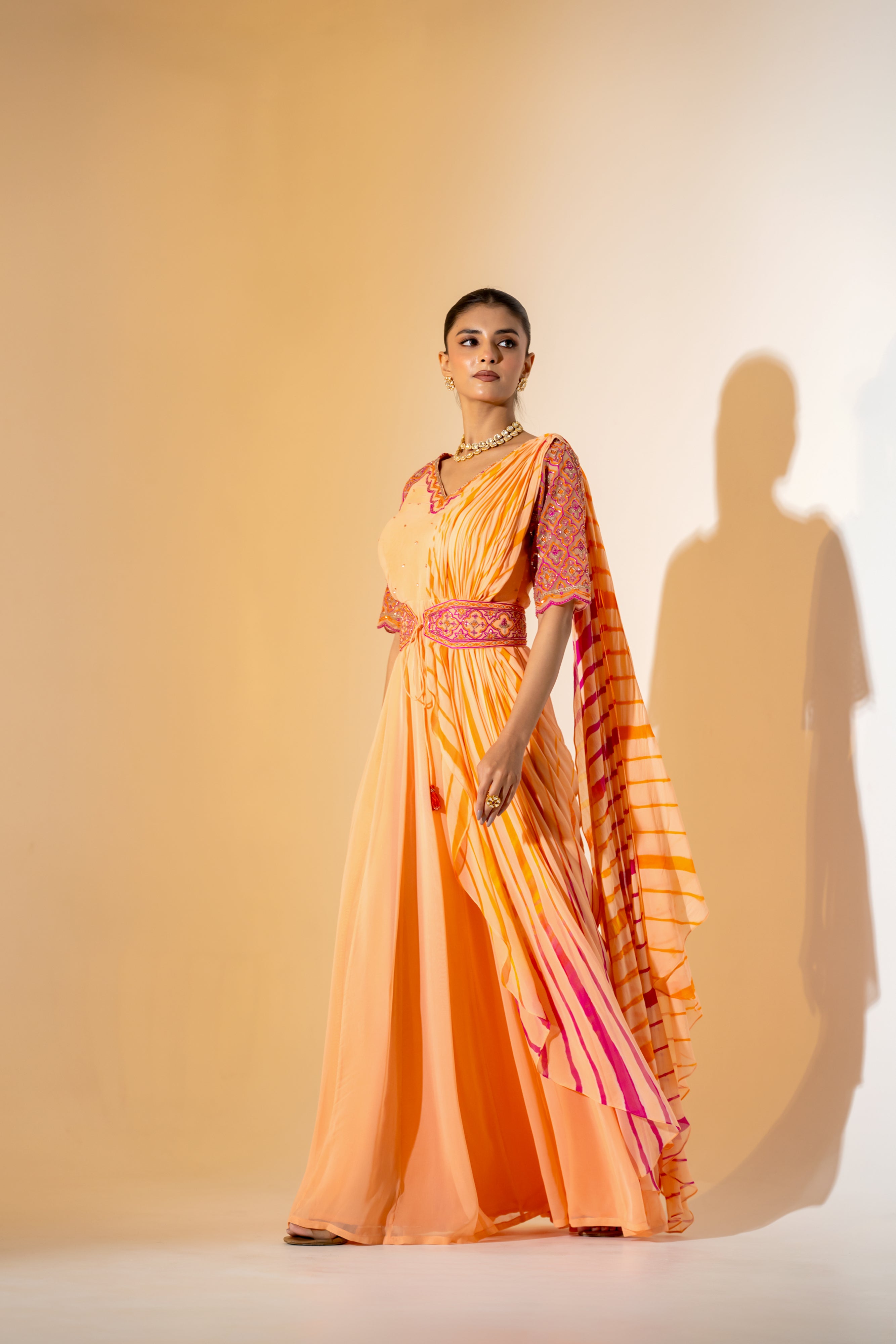 PEACH LEHERIYA DRAPED SAREE WITH EMBROIDERED NET SLEEVES & BELT.