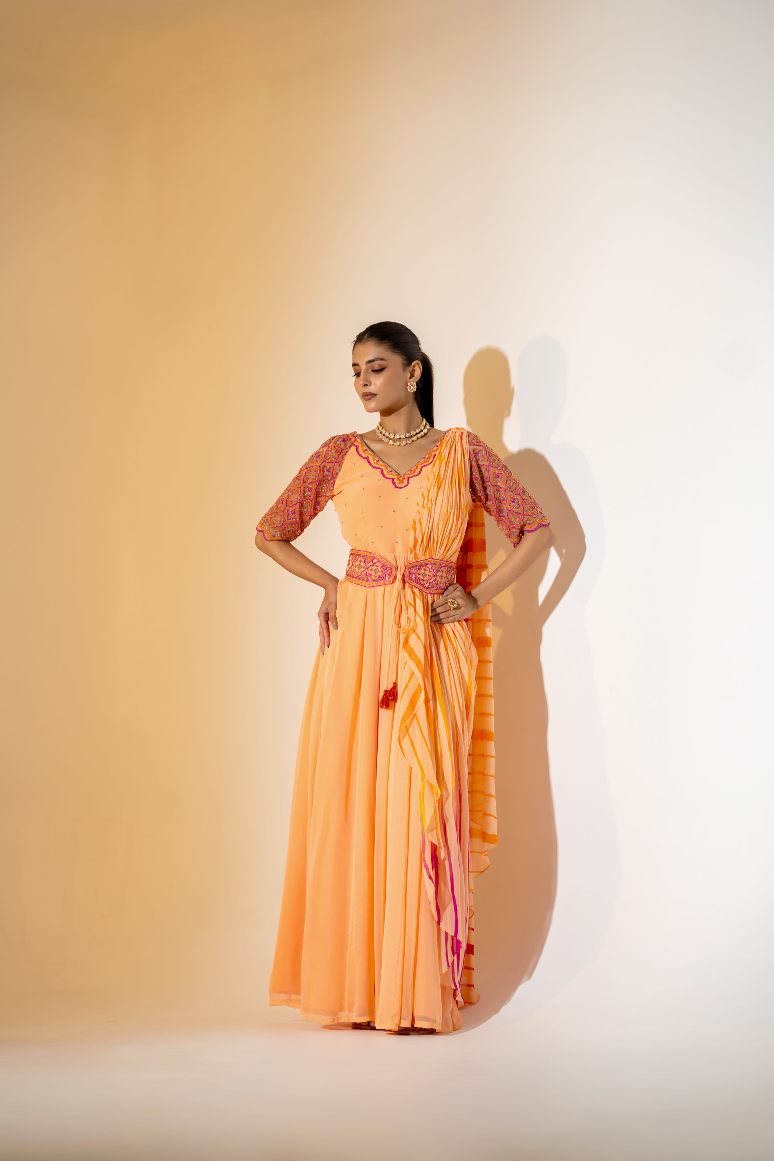 PEACH LEHERIYA DRAPED SAREE WITH EMBROIDERED NET SLEEVES & BELT.