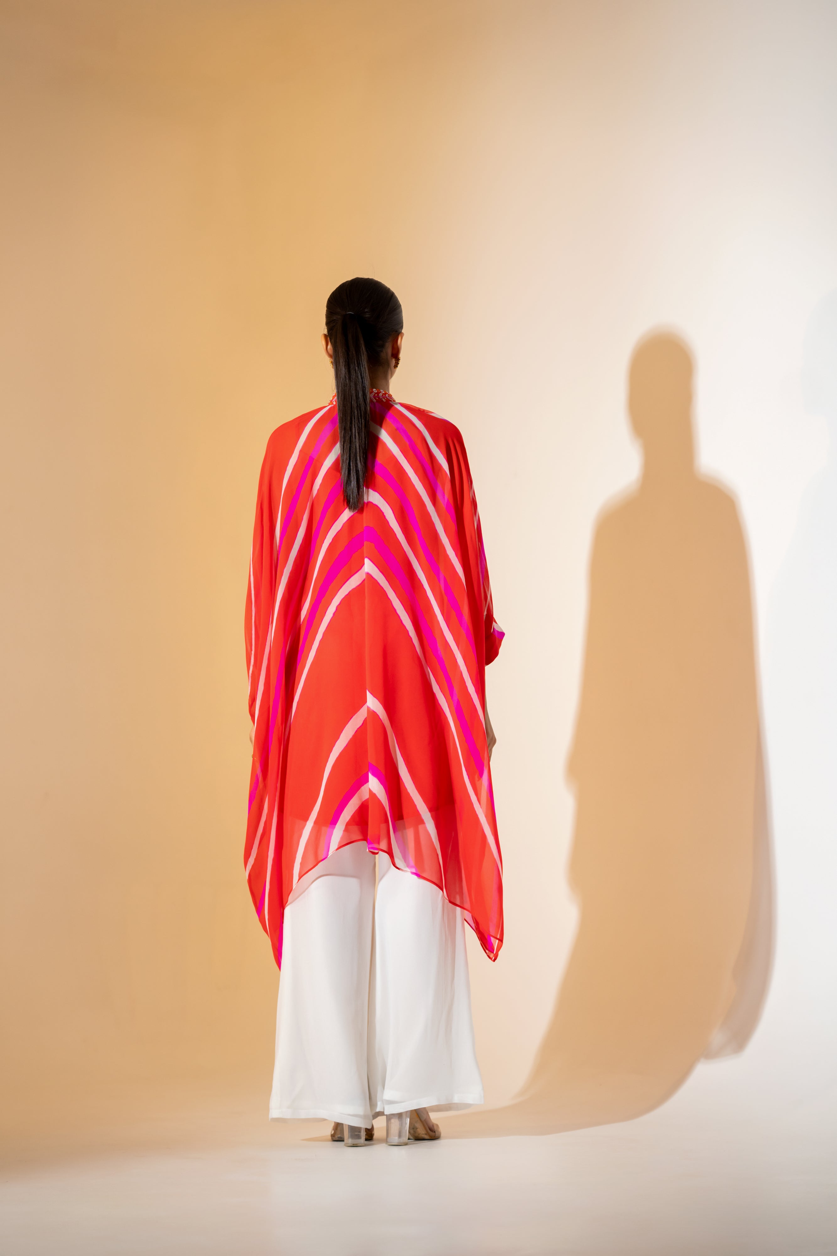 ORANGE AND PINK LEHERIYA KAFTAN TOP WITH EMBROIDERED NECKLINE & WHITE PANT.