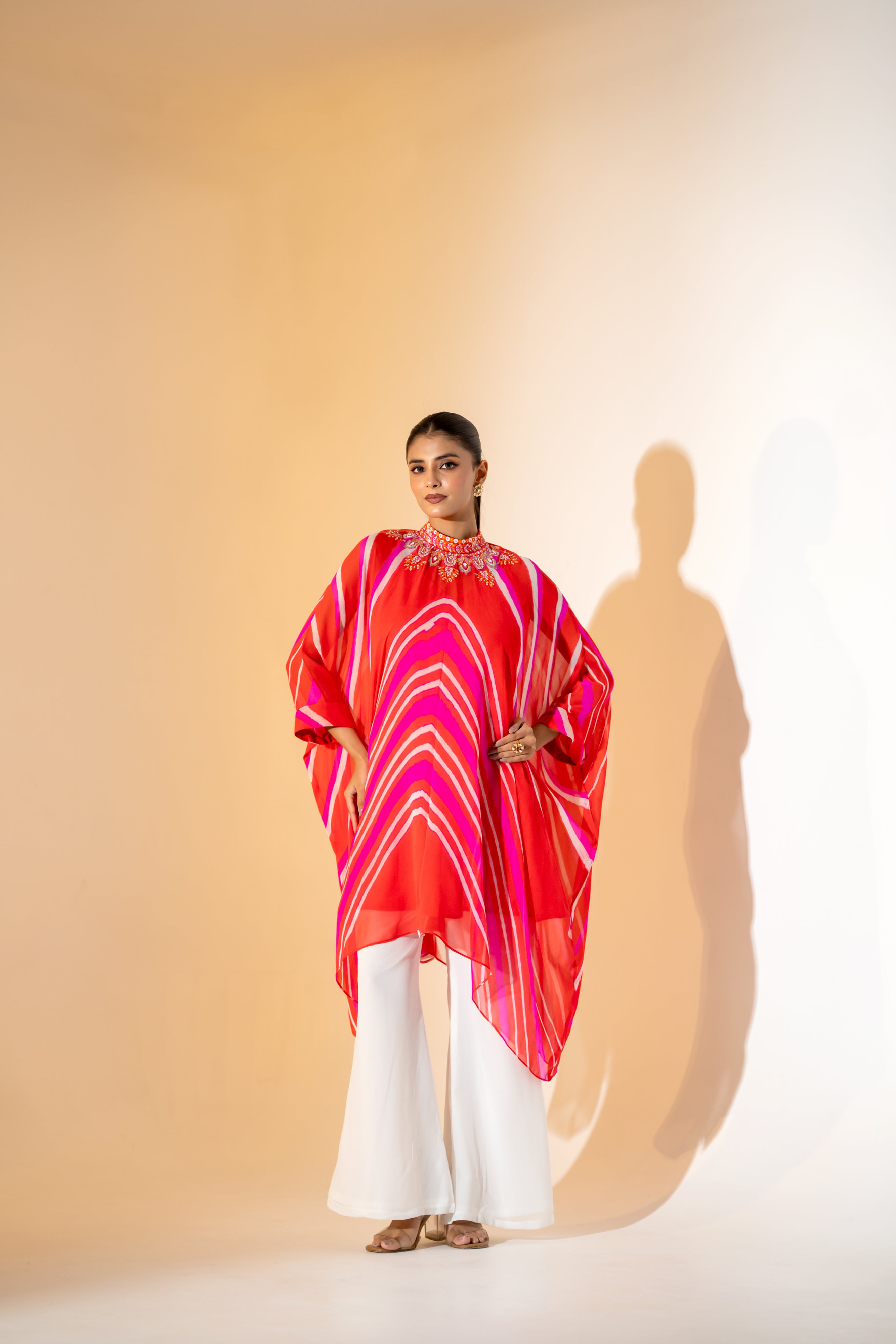 ORANGE AND PINK LEHERIYA KAFTAN TOP WITH EMBROIDERED NECKLINE & WHITE PANT.