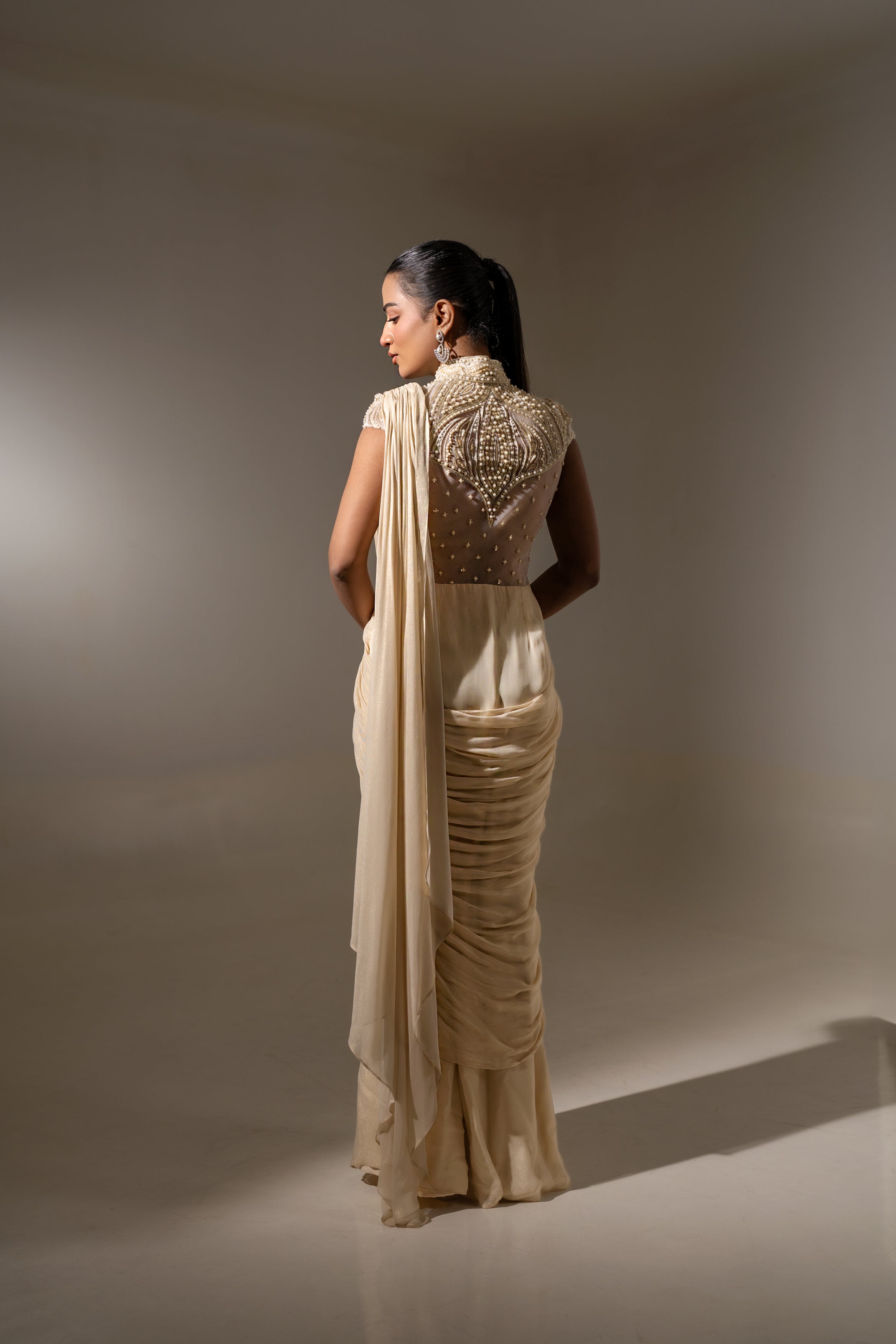 OFF WHITE EMBELLISHED SAREE WITH HIGH-NECK BODICE.