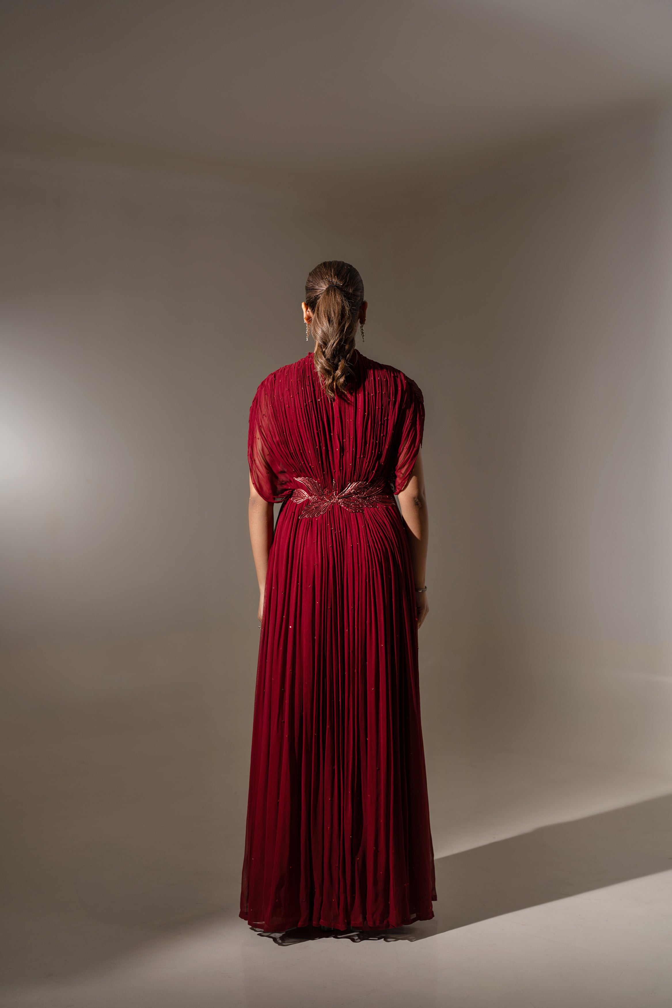 MAROON WIRE EMBELLISHED PLEATED GOWN WITH SHEER SLEEVES.