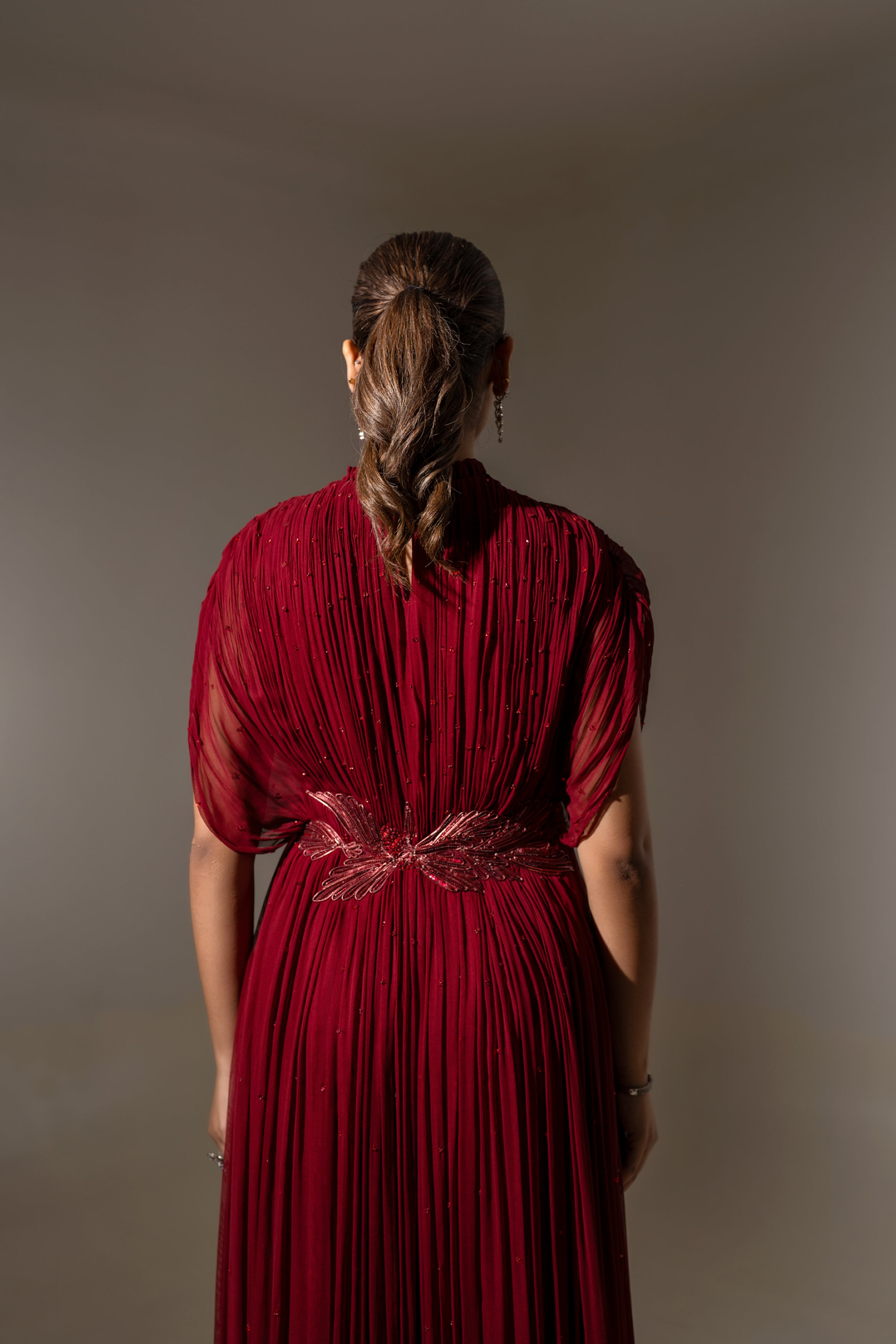 MAROON WIRE EMBELLISHED PLEATED GOWN WITH SHEER SLEEVES.