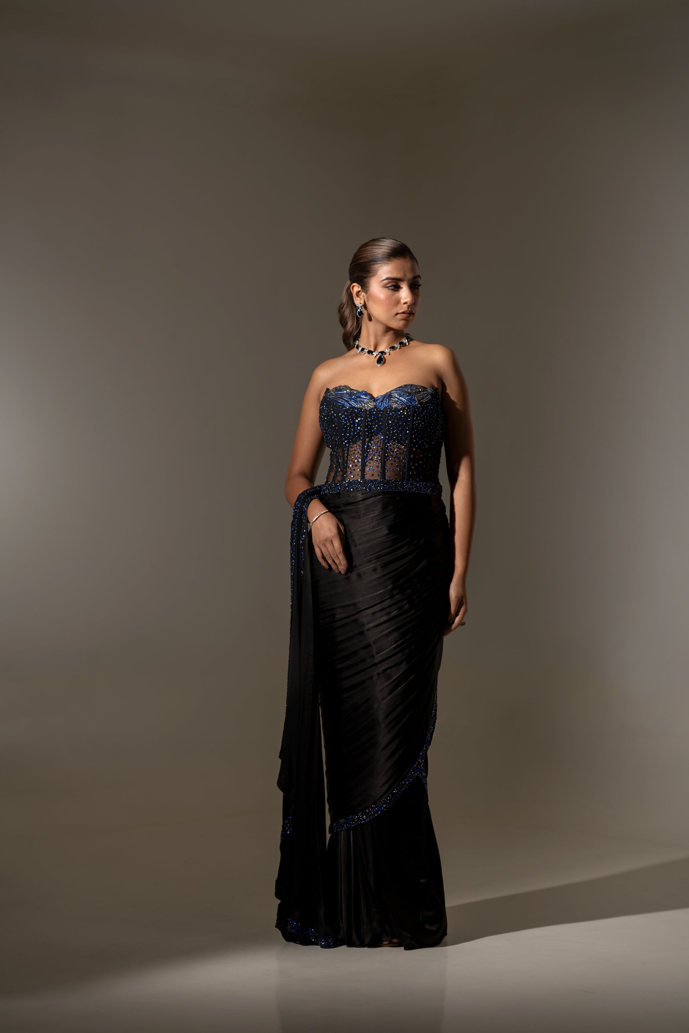 BLACK SEQUIN AND BEAD EMBELLISHED DRAPED SAREE WITH WIRE-WORK BUSTIER.