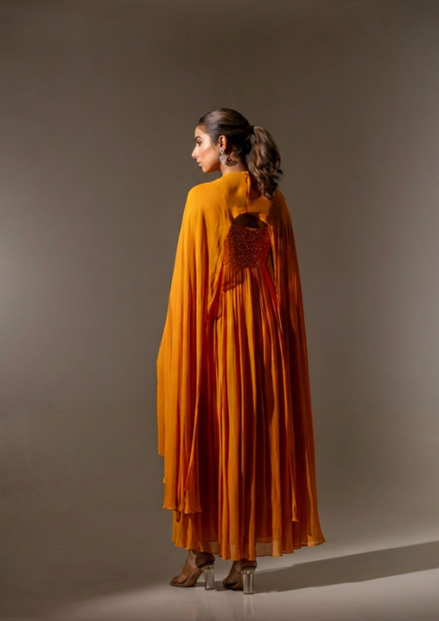 RUST EMBELLISHED CAPE STYLE PLEATED GOWN.