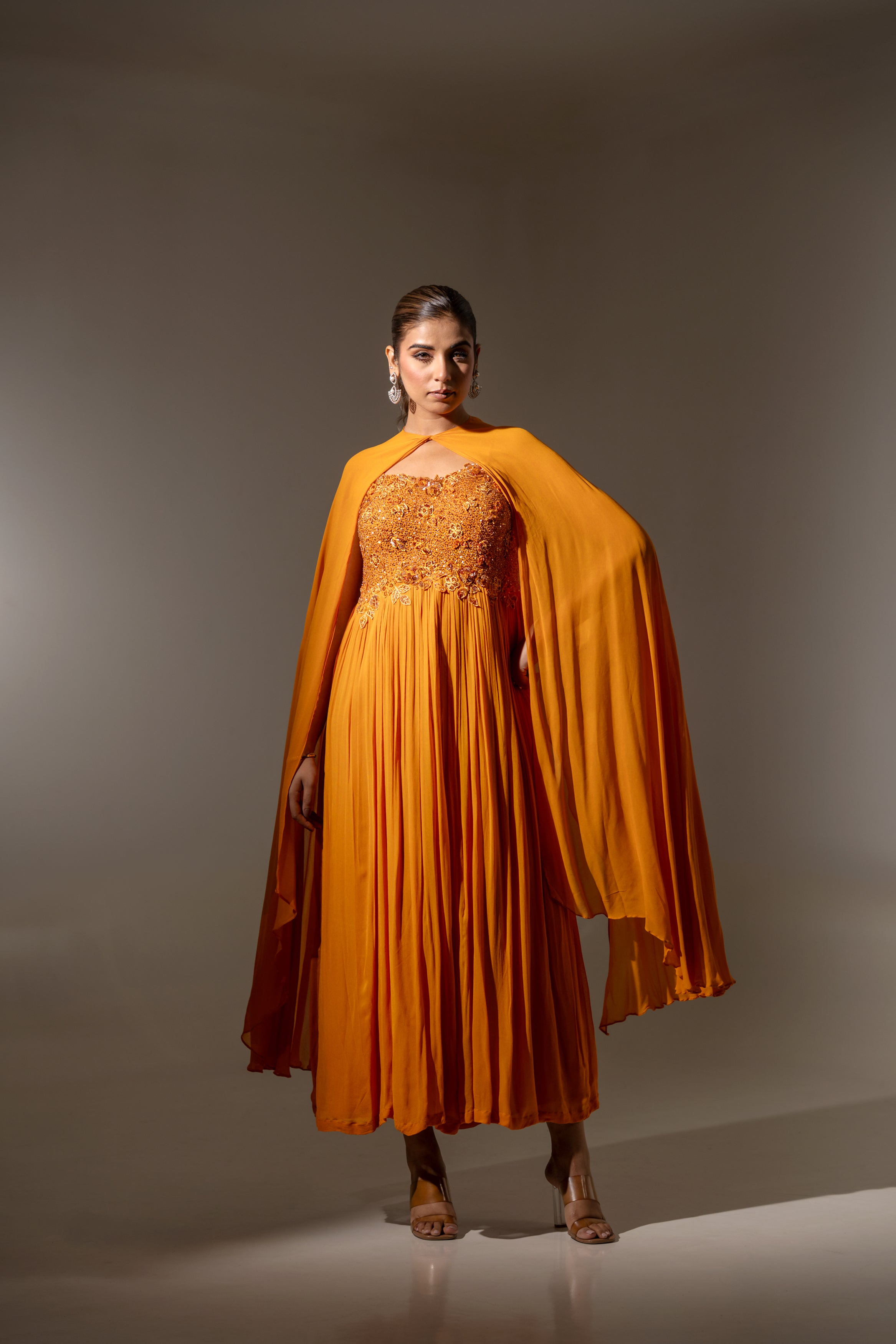 RUST EMBELLISHED CAPE STYLE PLEATED GOWN.