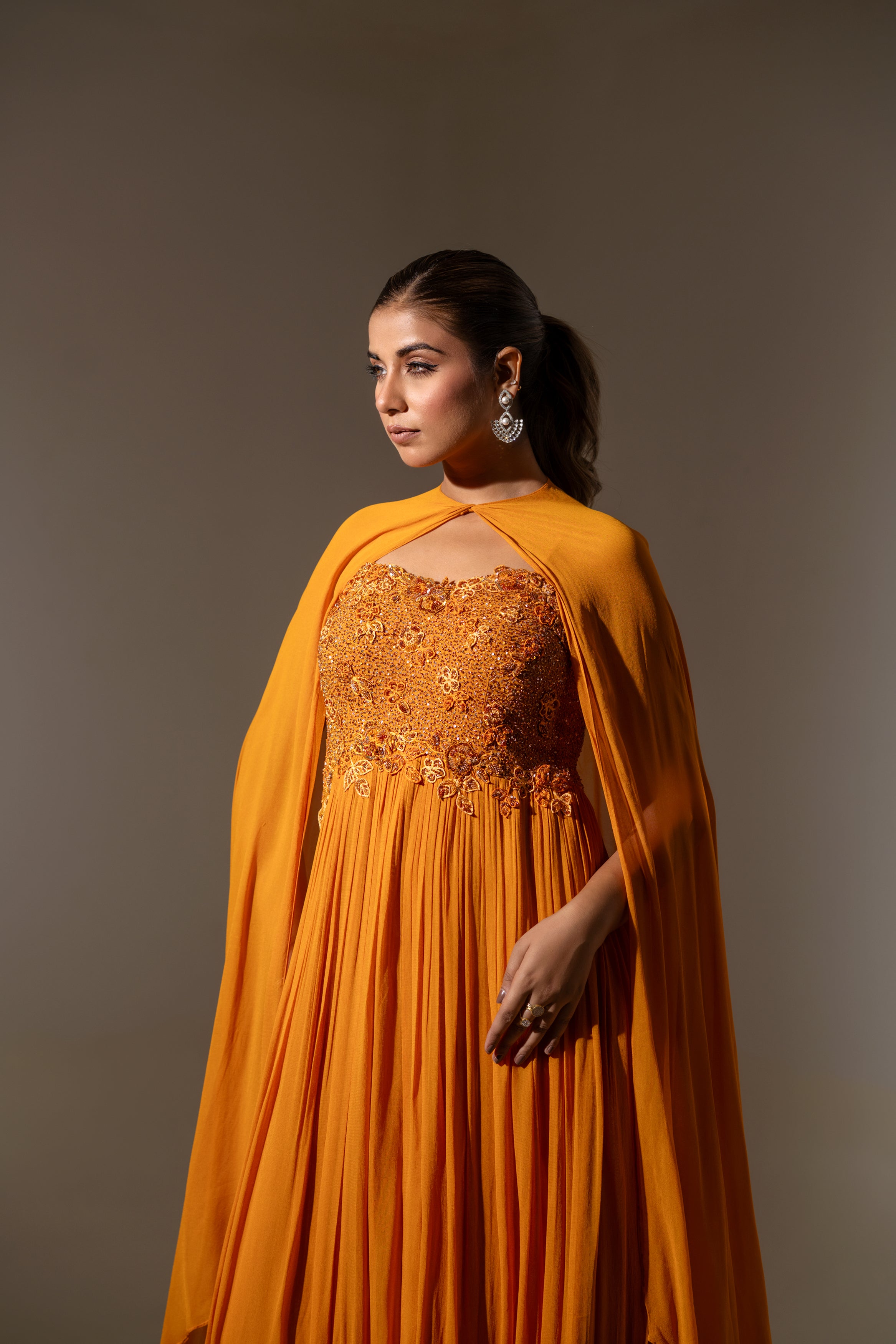 RUST EMBELLISHED CAPE STYLE PLEATED GOWN.