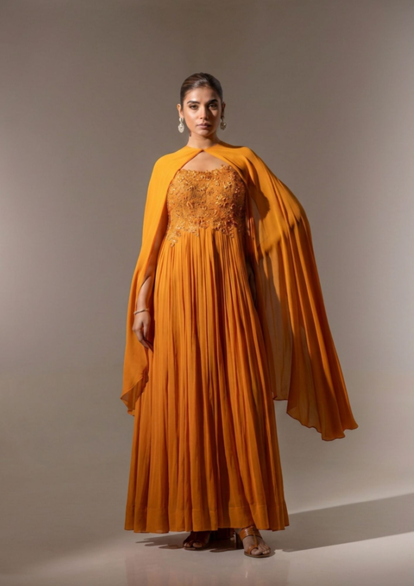 RUST EMBELLISHED CAPE STYLE PLEATED GOWN.