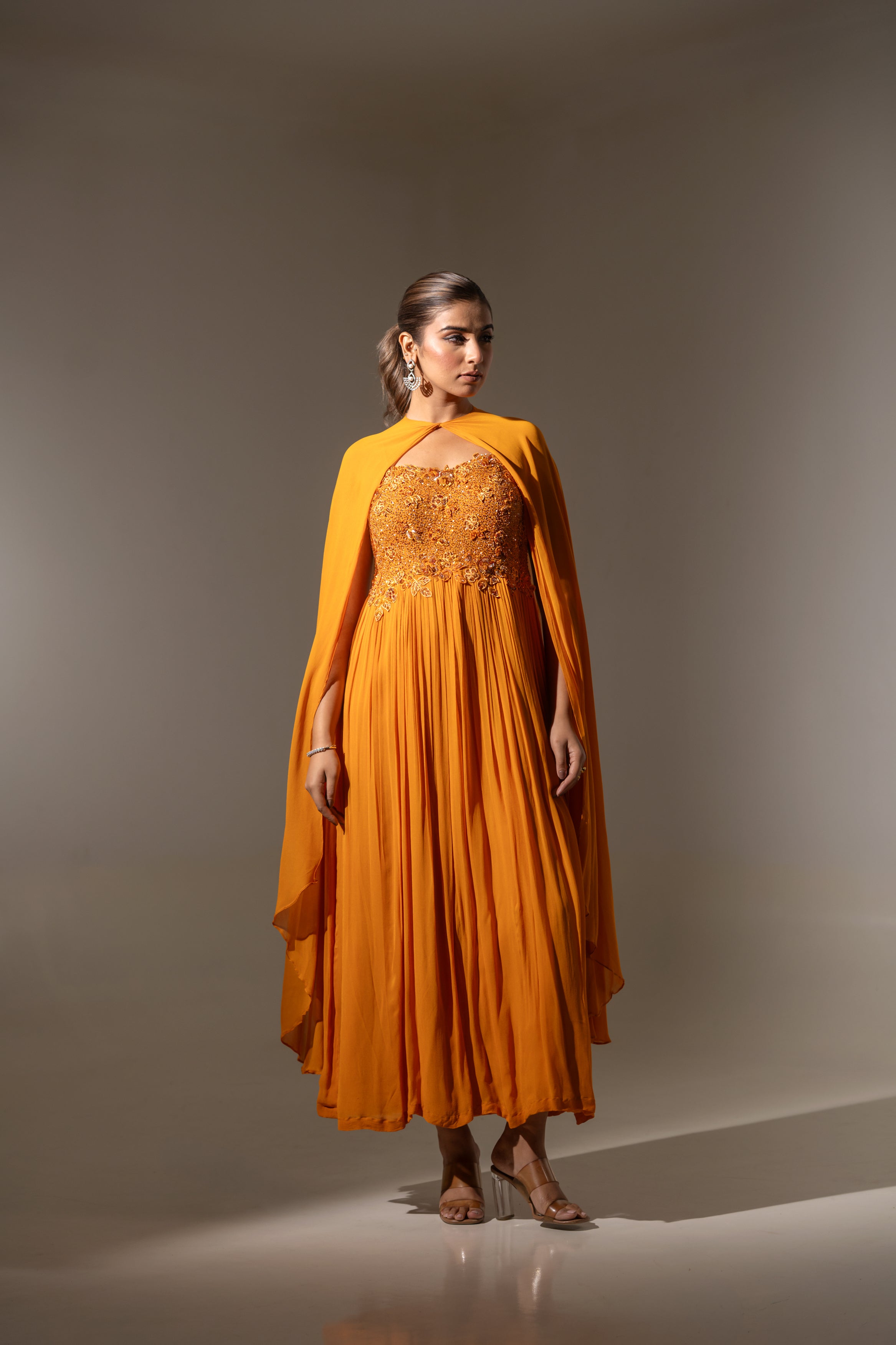 RUST EMBELLISHED CAPE STYLE PLEATED GOWN.