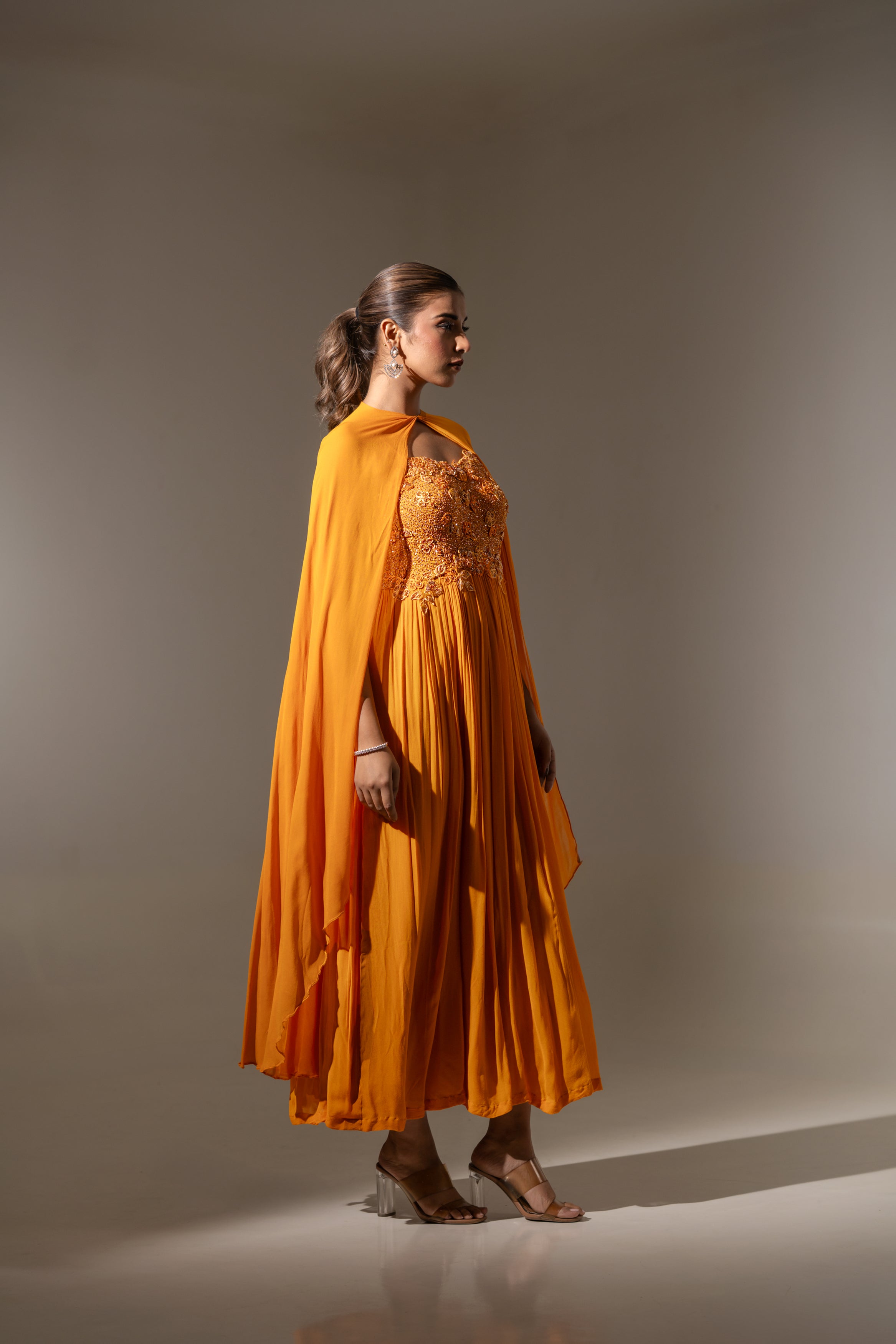RUST EMBELLISHED CAPE STYLE PLEATED GOWN.