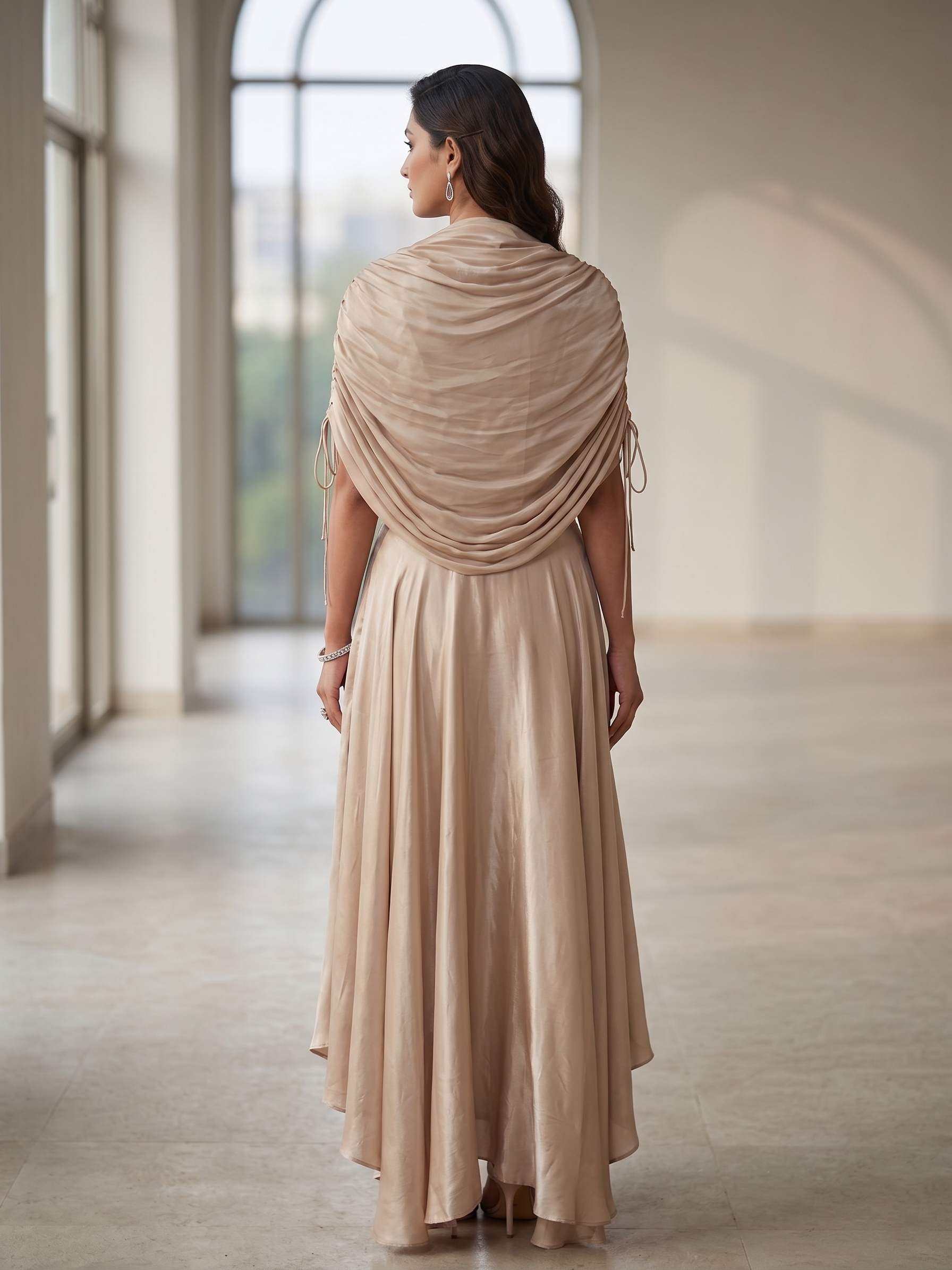 BEIGE BEAD AND WIRE EMBELLISHED CAPE TOP WITH DRAPED SKIRT.