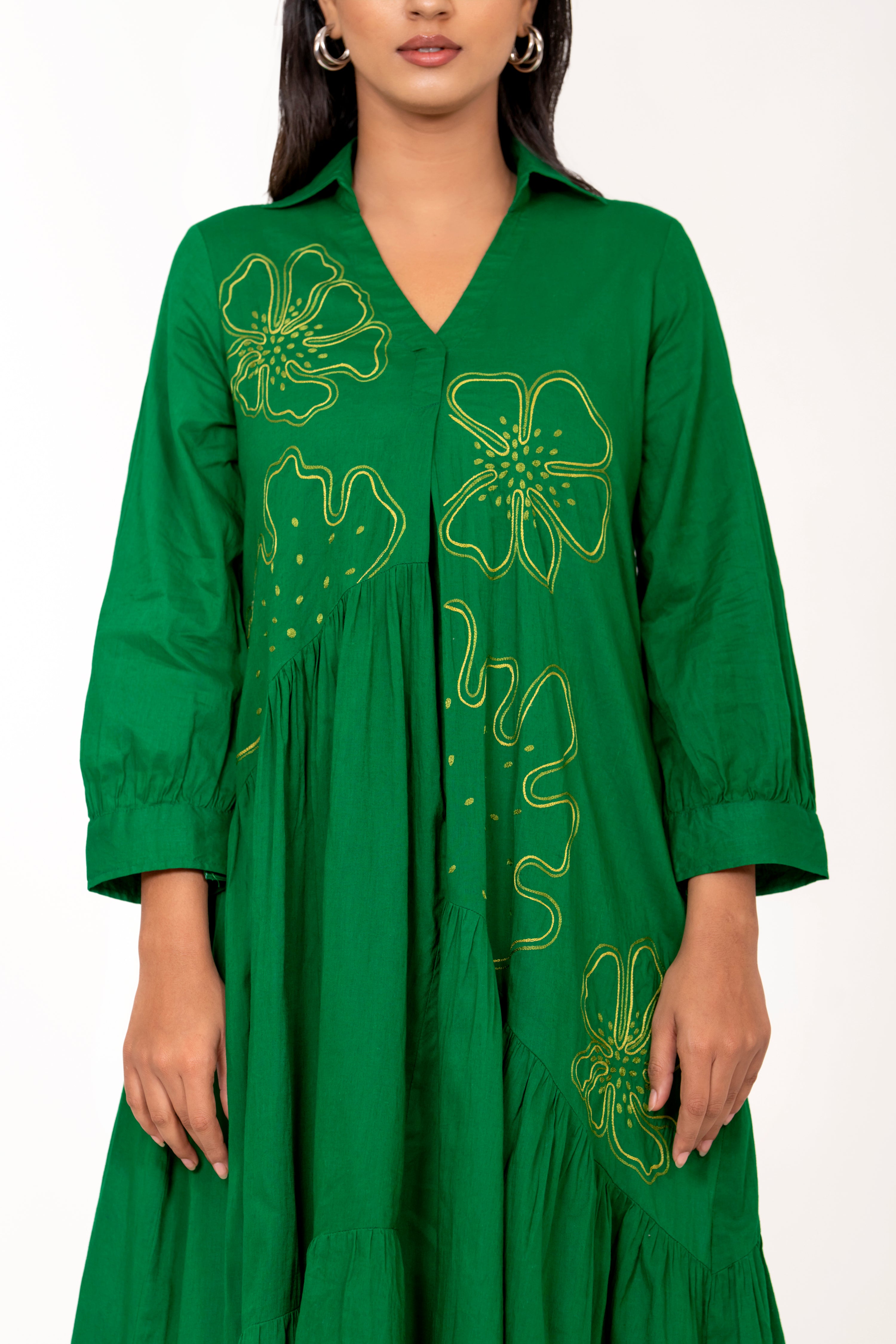 ELEGANT GREEN FLARED DRESS FEATURING DELICATE FLORAL EMBROIDERY.