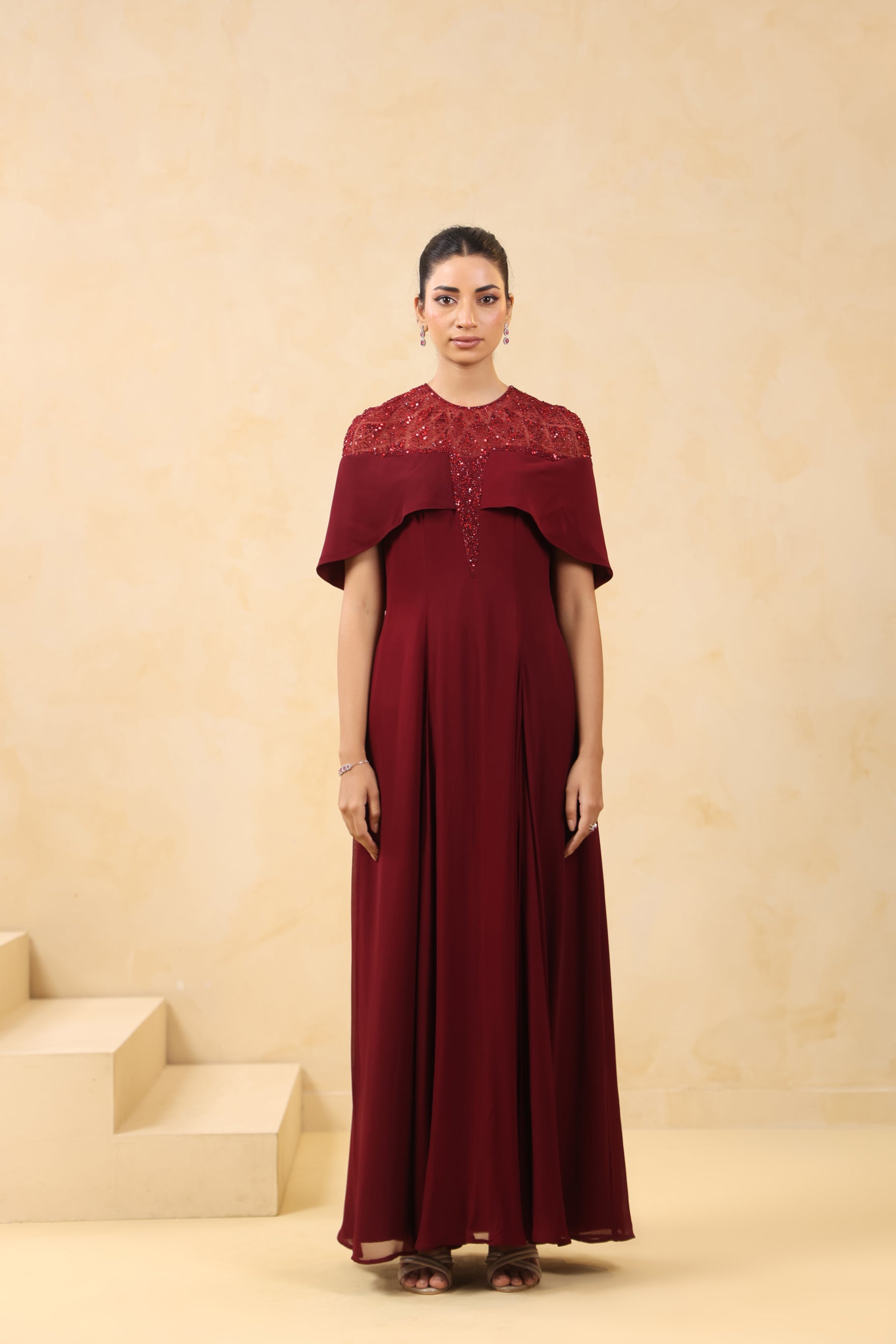 MAROON SEQUIN AND BEAD EMBELLISHED GOWN WITH SHEER NECKLINE.