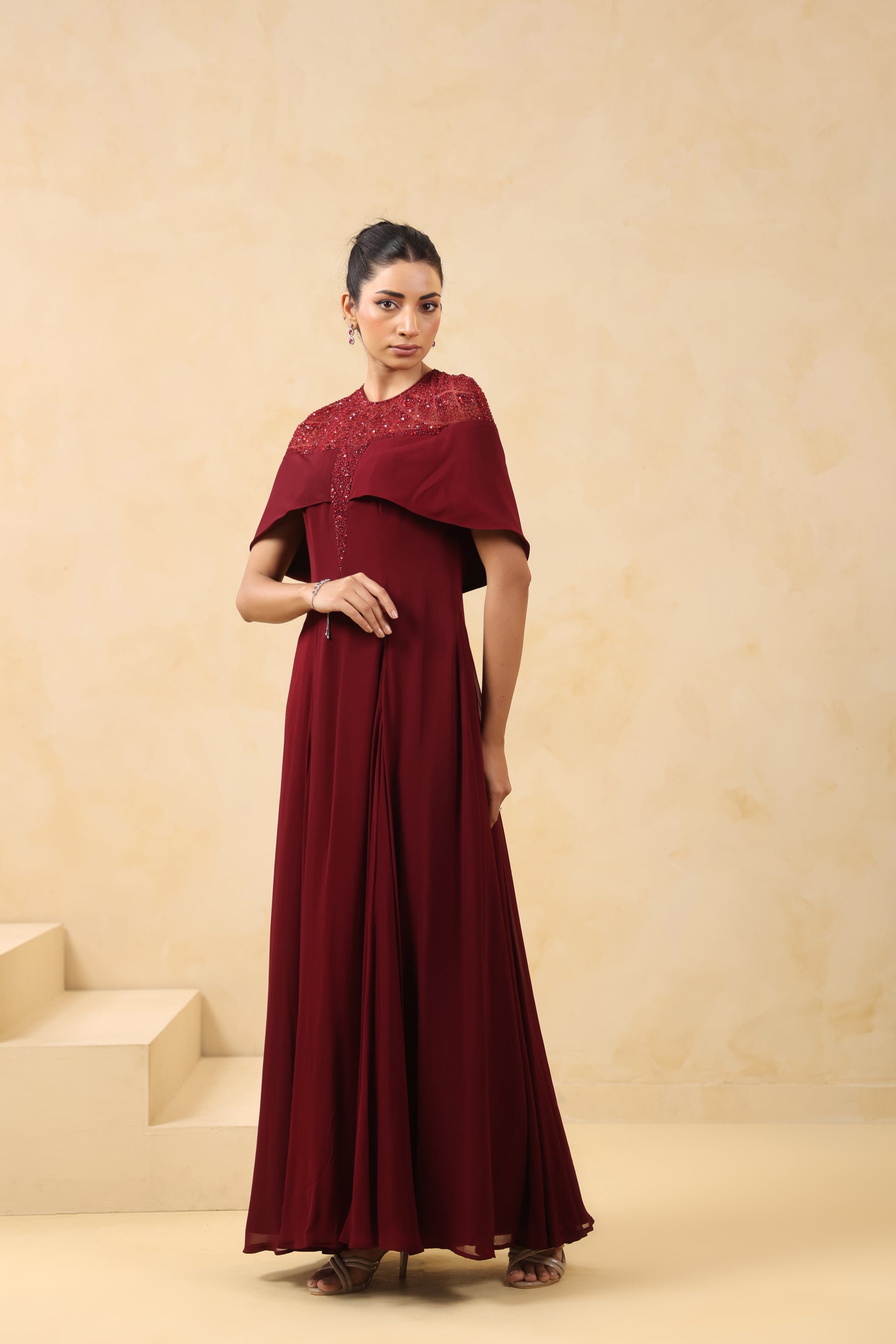 MAROON SEQUIN AND BEAD EMBELLISHED GOWN WITH SHEER NECKLINE.