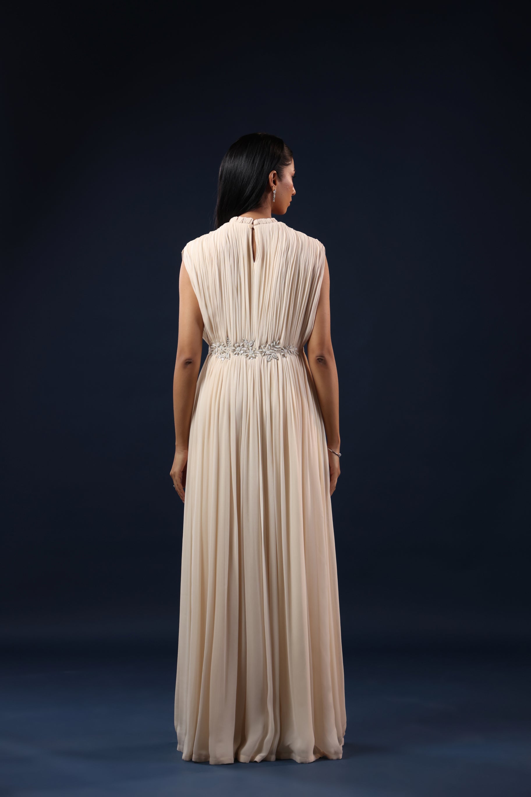 ELEGANT OFF WHITE PLEATED GOWN WITH EMBELLISHED WAIST.