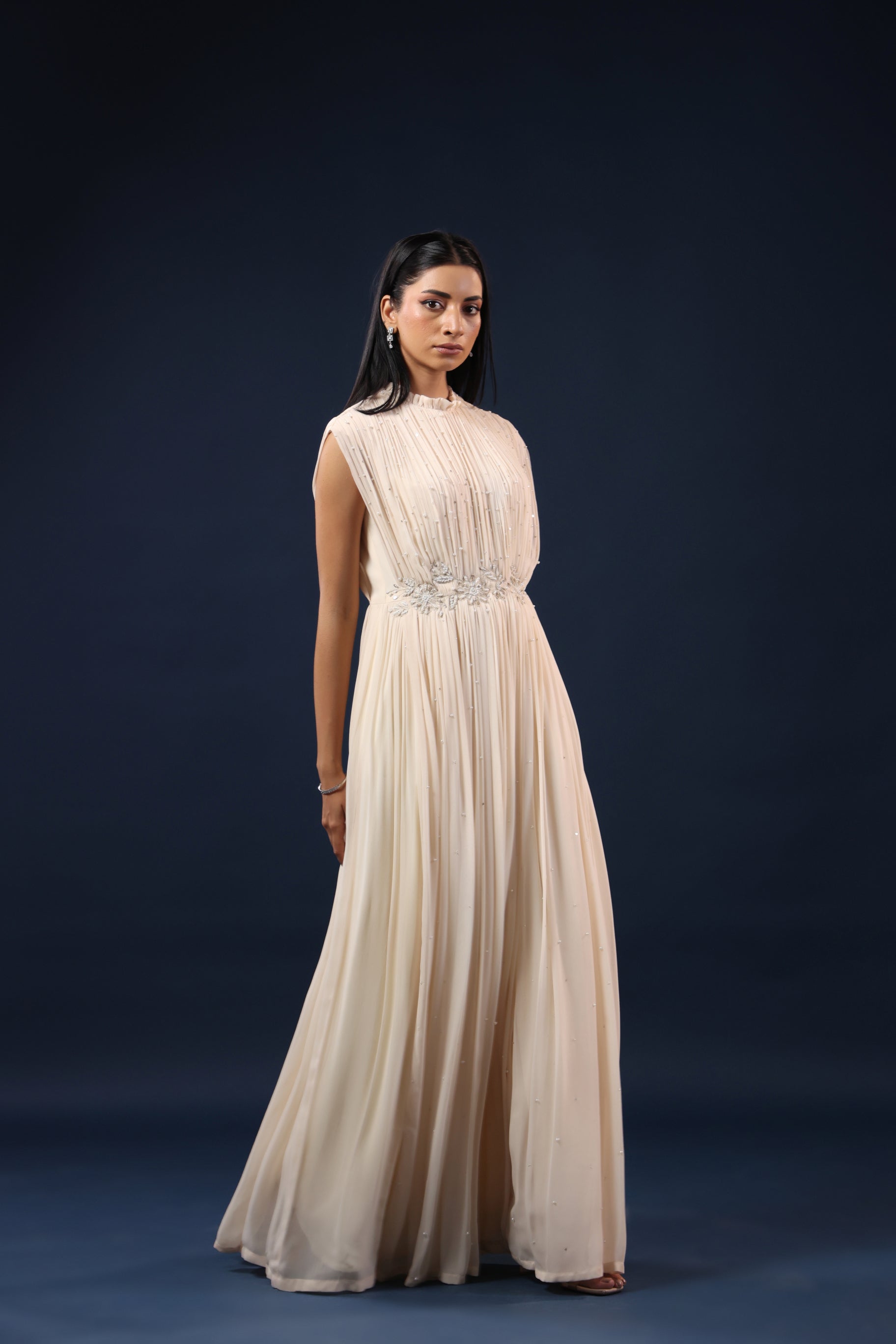 ELEGANT OFF WHITE PLEATED GOWN WITH EMBELLISHED WAIST.