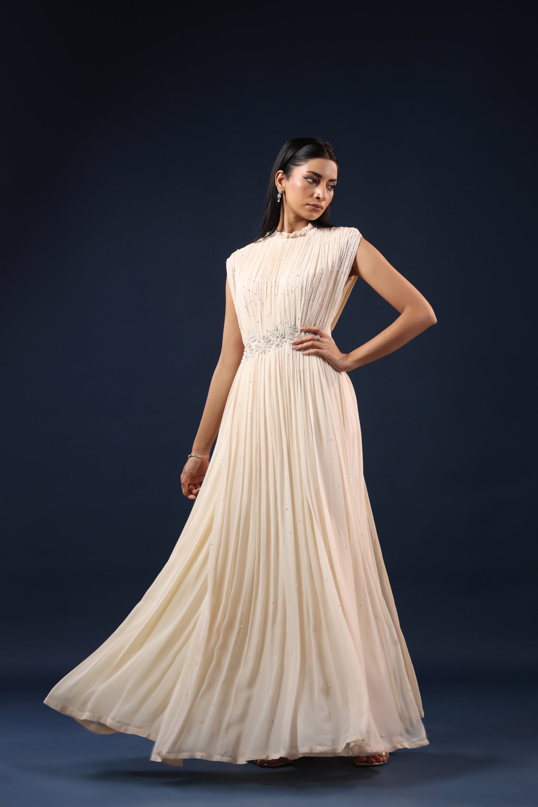 ELEGANT OFF WHITE PLEATED GOWN WITH EMBELLISHED WAIST.