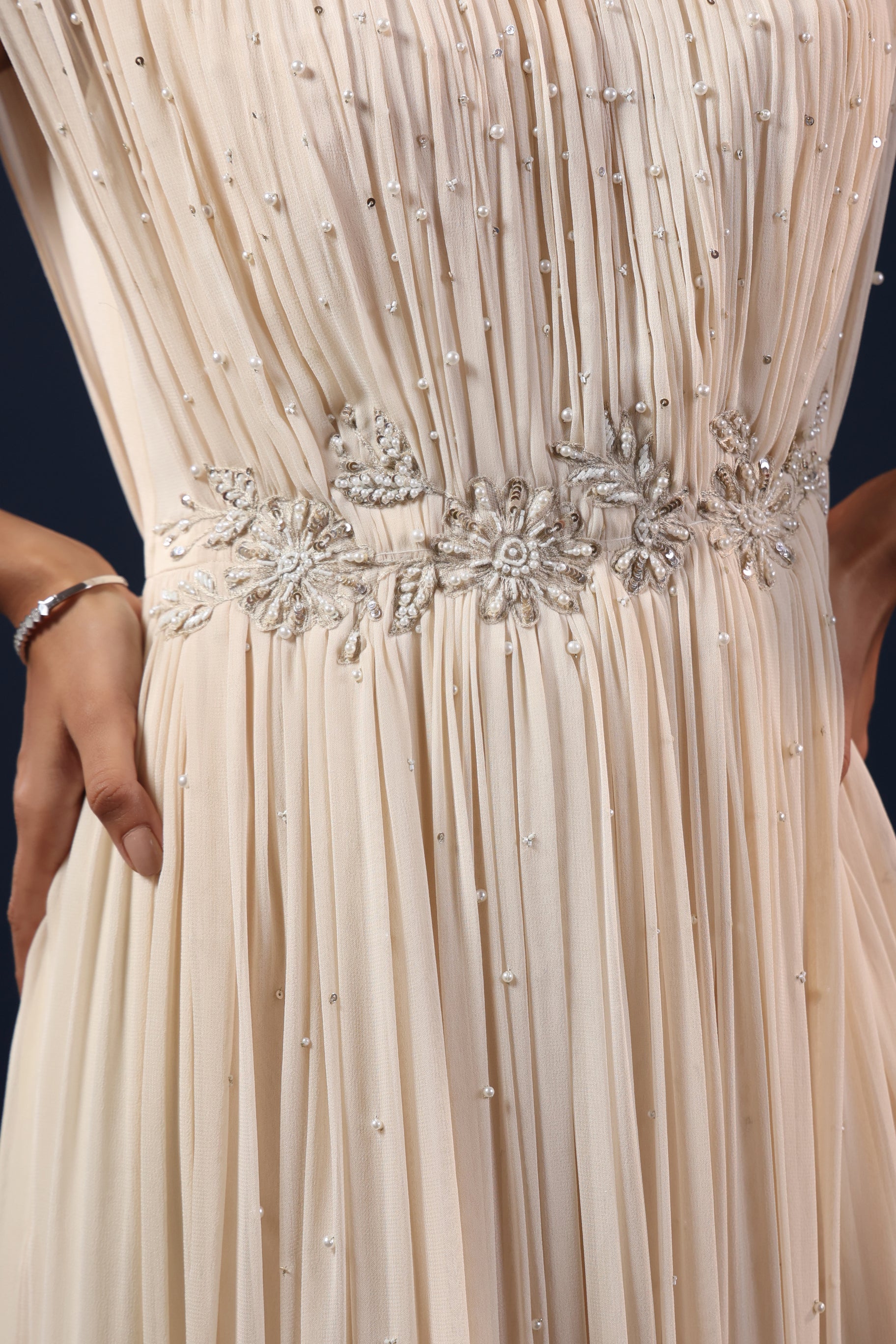 ELEGANT OFF WHITE PLEATED GOWN WITH EMBELLISHED WAIST.