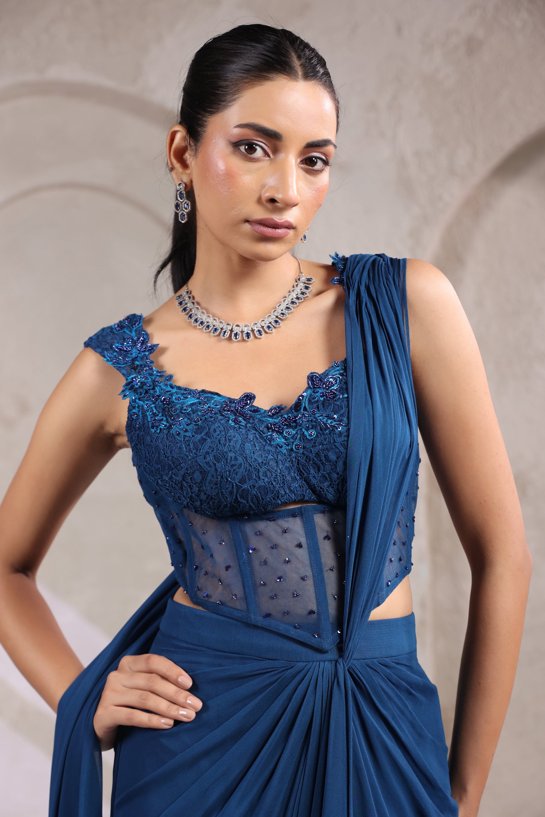 MIDNIGHT TEAL BLUE CORSET DRAPE SAREE WITH FLORAL NECKLINE.