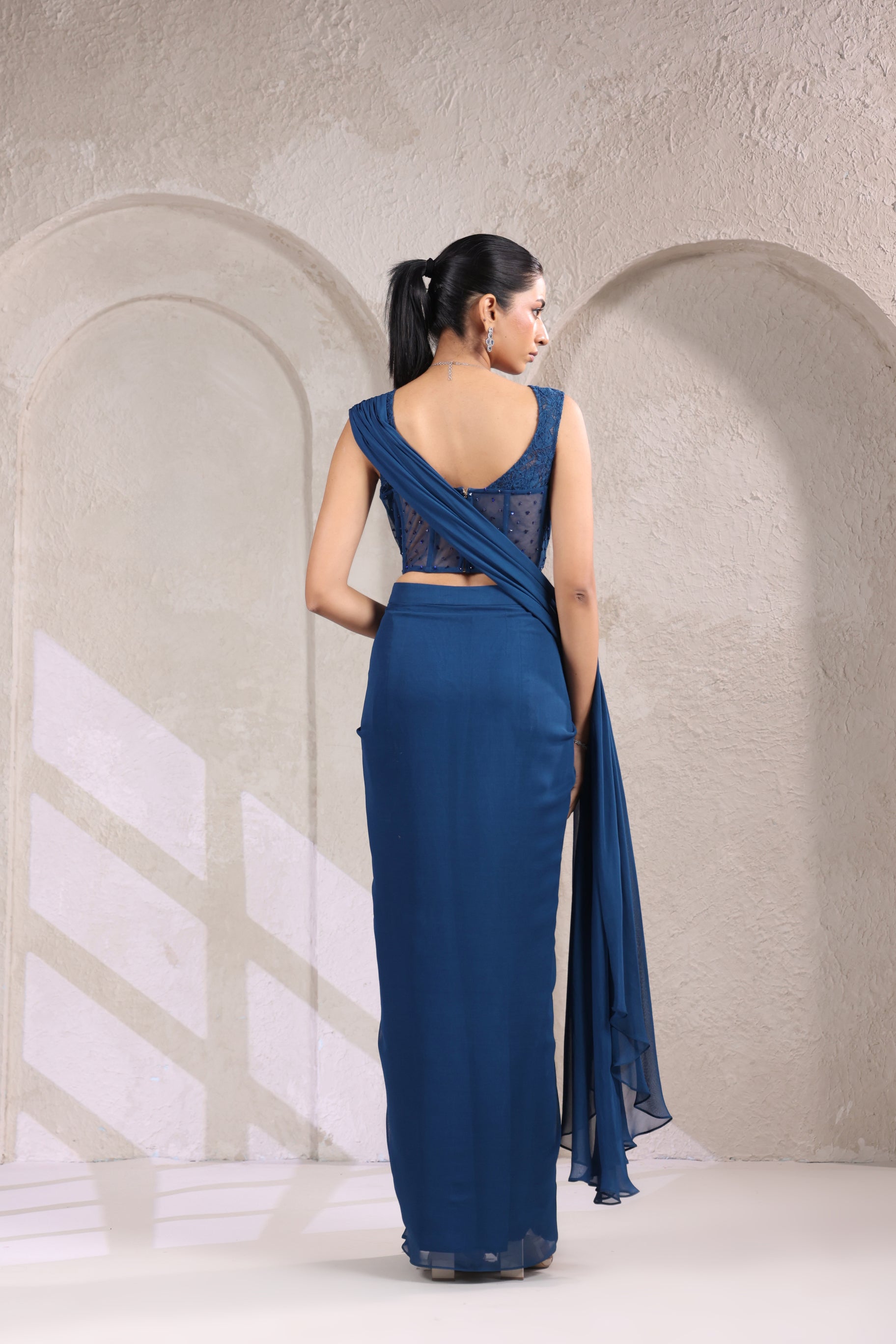 MIDNIGHT TEAL BLUE CORSET DRAPE SAREE WITH FLORAL NECKLINE.