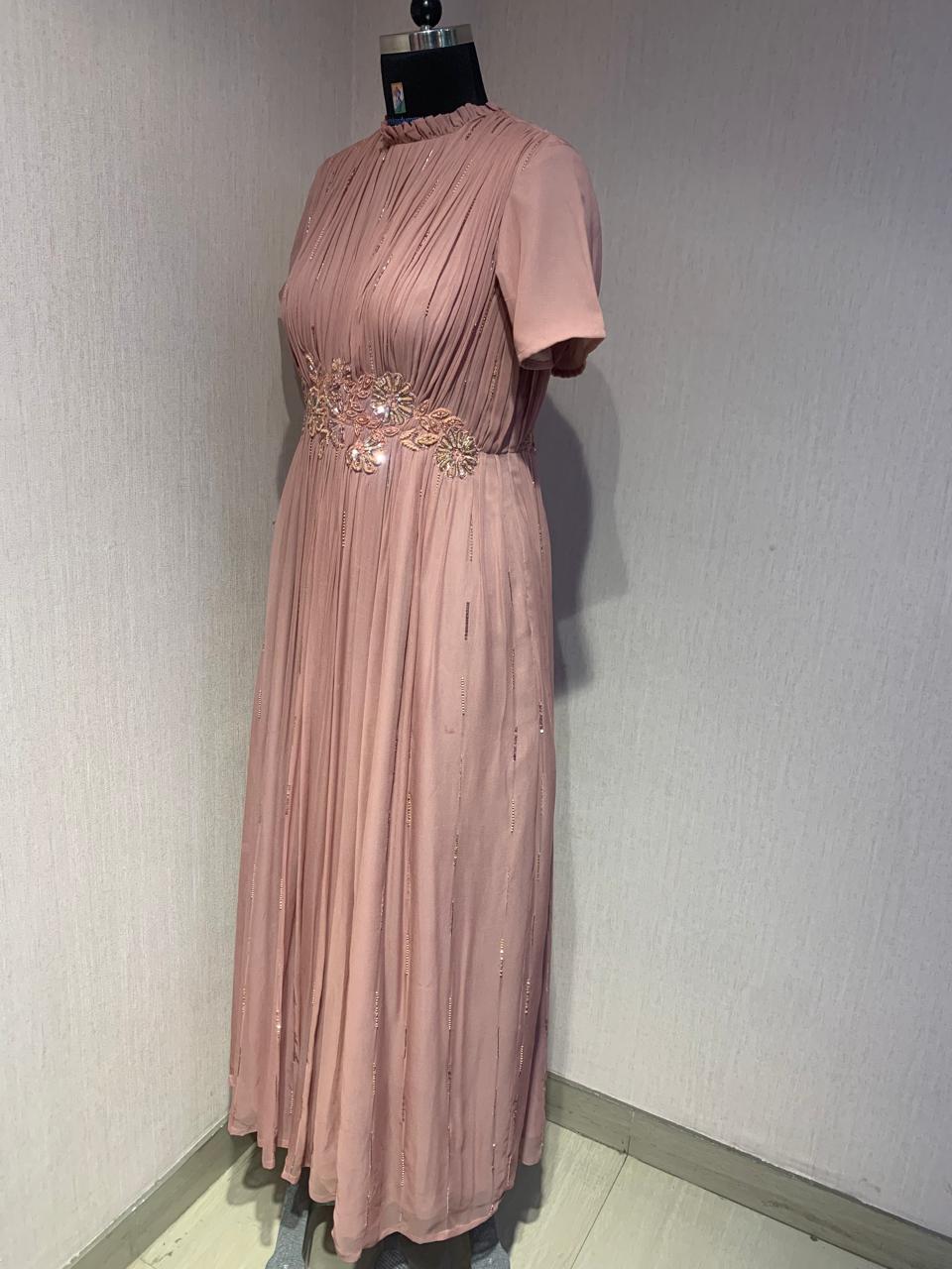 PINK GEORGETTE GOWN WITH APPLIQUE FLOWERS AT THE WAIST.