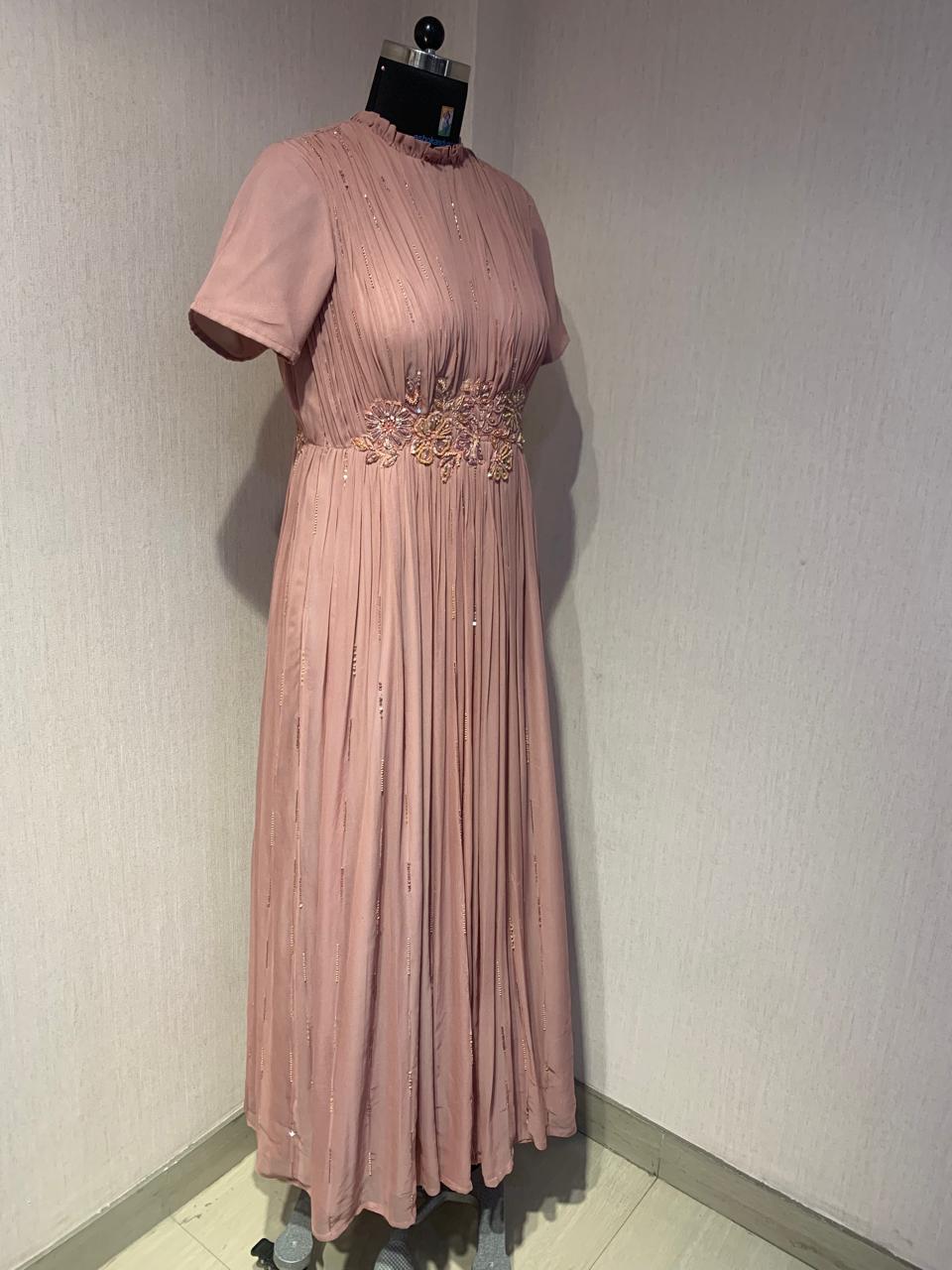 PINK GEORGETTE GOWN WITH APPLIQUE FLOWERS AT THE WAIST.