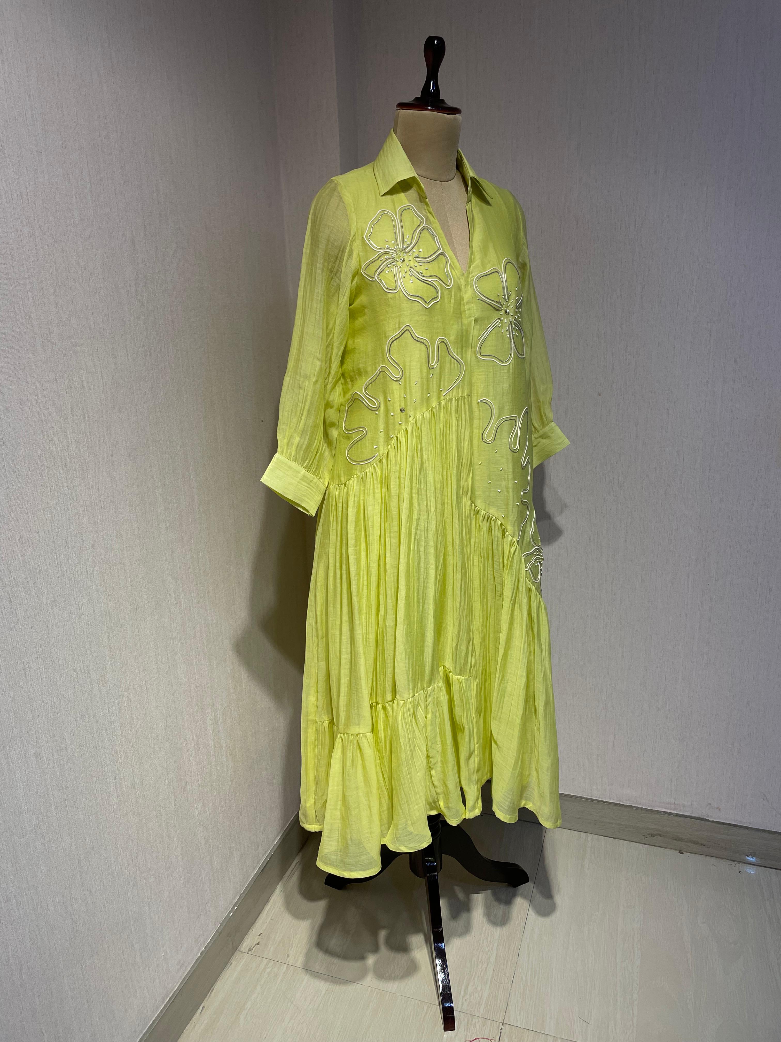 ELEGANT GREEN FLARED DRESS FEATURING DELICATE FLORAL EMBROIDERY.