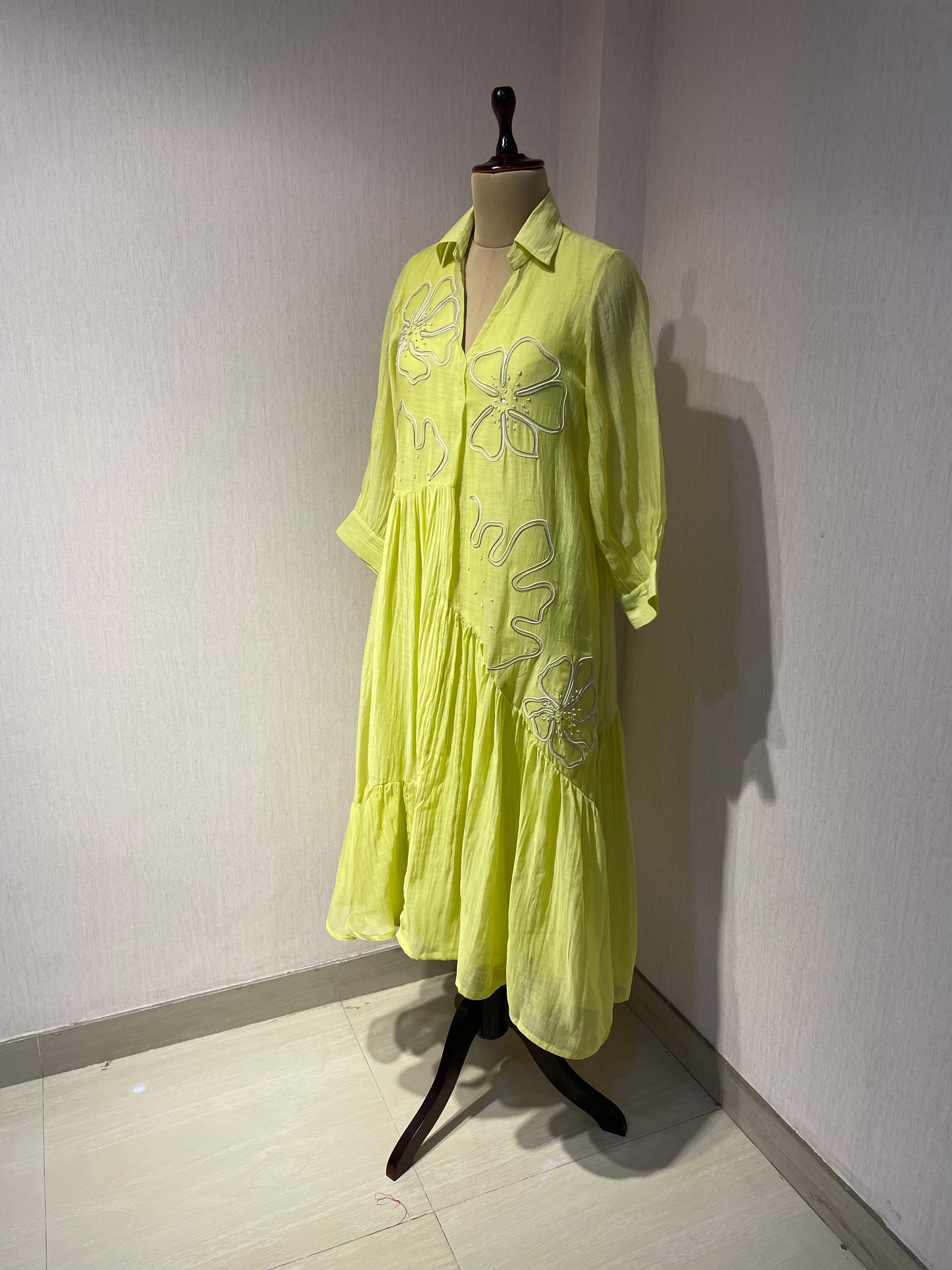 ELEGANT GREEN FLARED DRESS FEATURING DELICATE FLORAL EMBROIDERY.