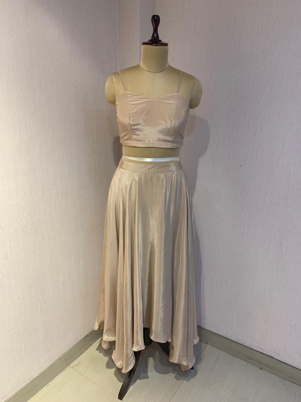 BEIGE BEAD AND WIRE EMBELLISHED CAPE TOP WITH DRAPED SKIRT.