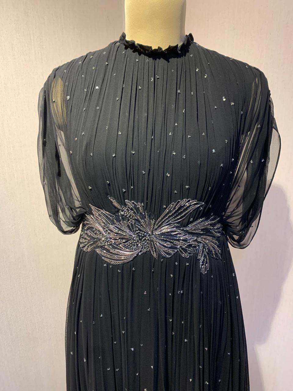 BLACK SEQUIN AND WIRE EMBELLISHED PLEATED GOWN WITH SHEER SLEEVES.