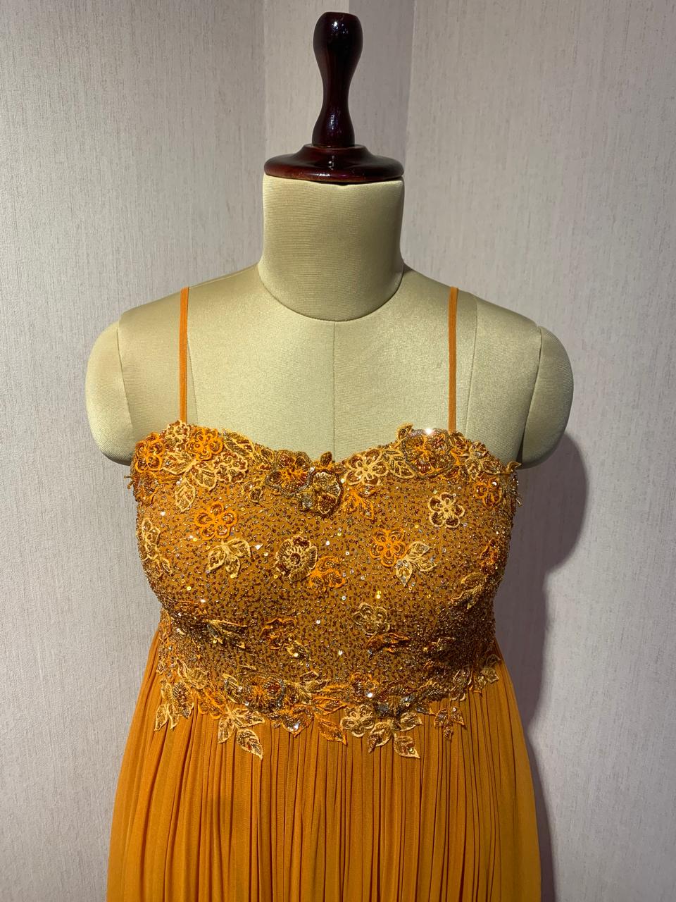 RUST EMBELLISHED CAPE STYLE PLEATED GOWN.