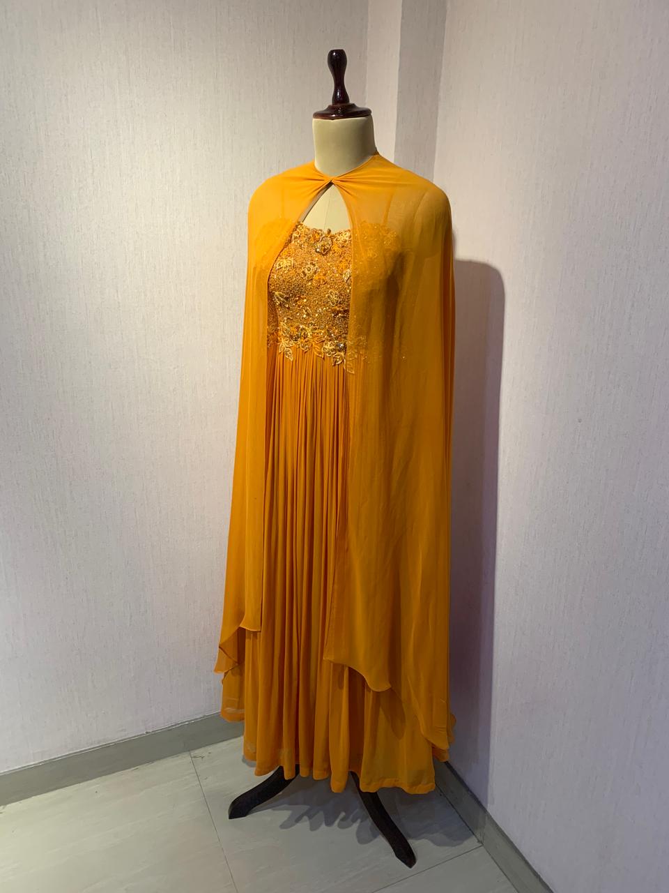 RUST EMBELLISHED CAPE STYLE PLEATED GOWN.