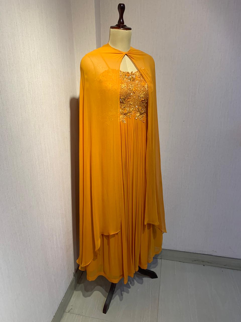 RUST EMBELLISHED CAPE STYLE PLEATED GOWN.