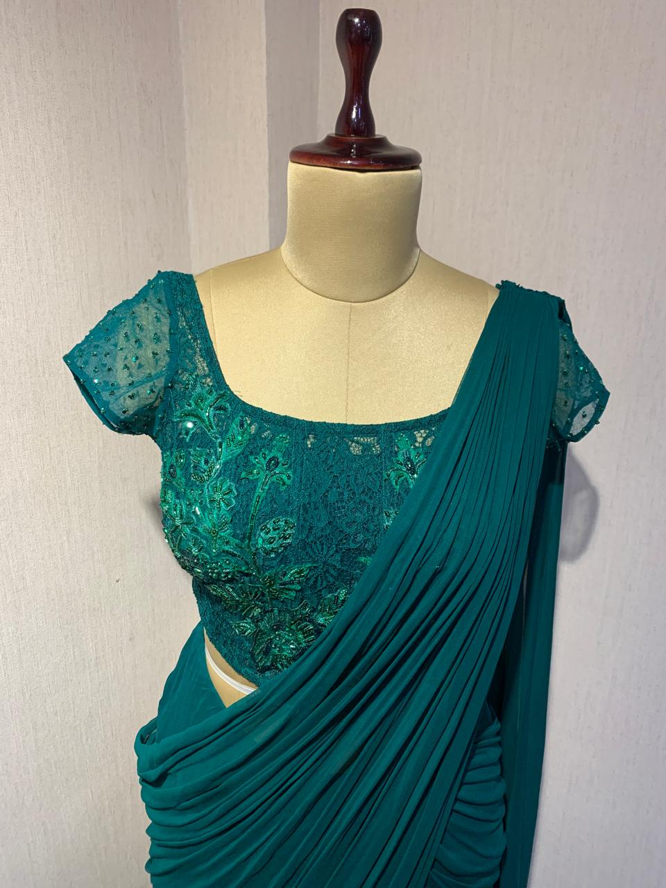 EMERALD GREEN EMBROIDERED DRAPED SAREE.
