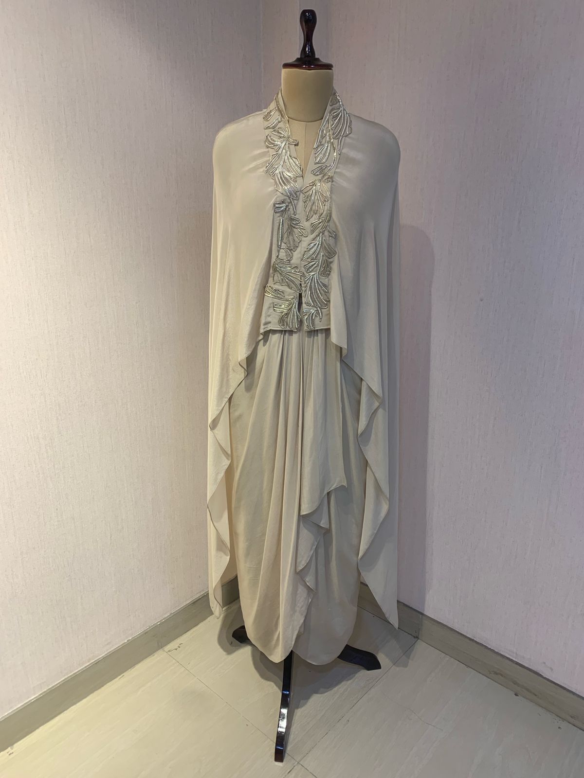 OFF WHITE EMBELLISHED CAPE WITH DRAPED SKIRT.
