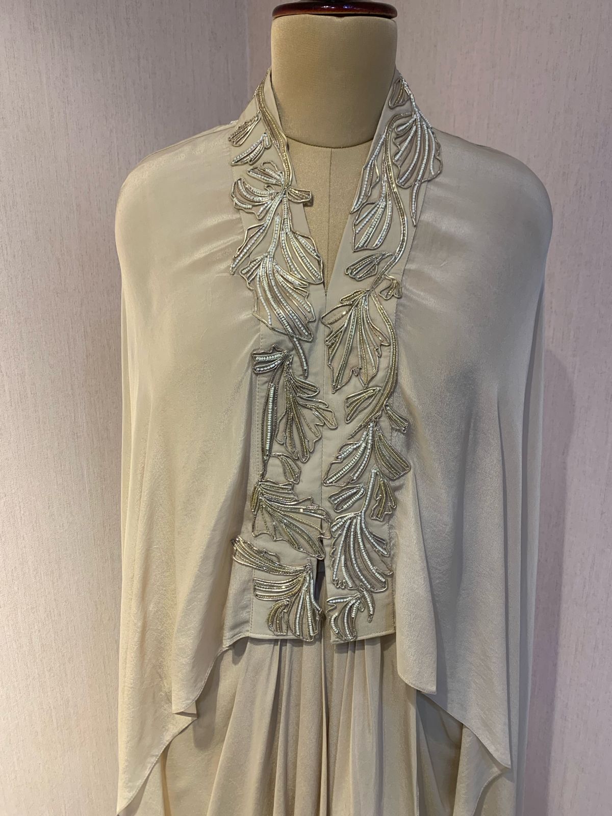 OFF WHITE EMBELLISHED CAPE WITH DRAPED SKIRT.