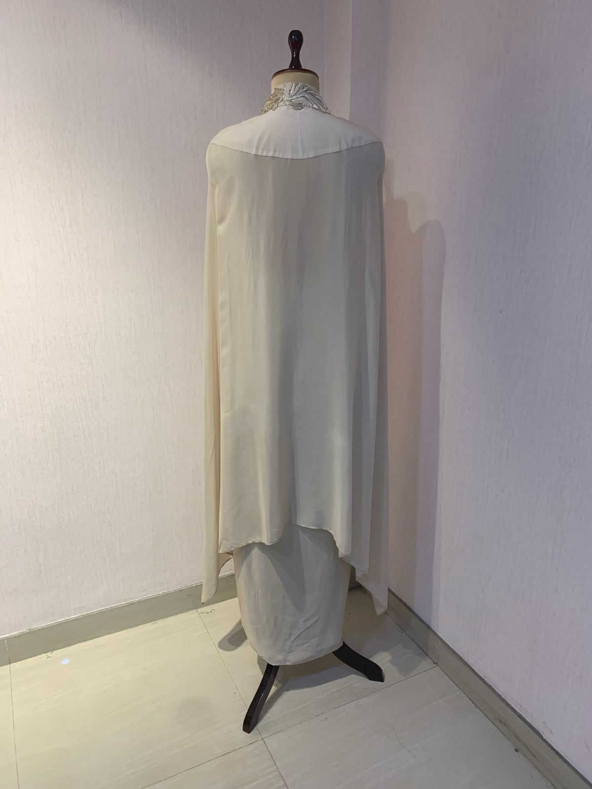 OFF WHITE EMBELLISHED CAPE WITH DRAPED SKIRT.