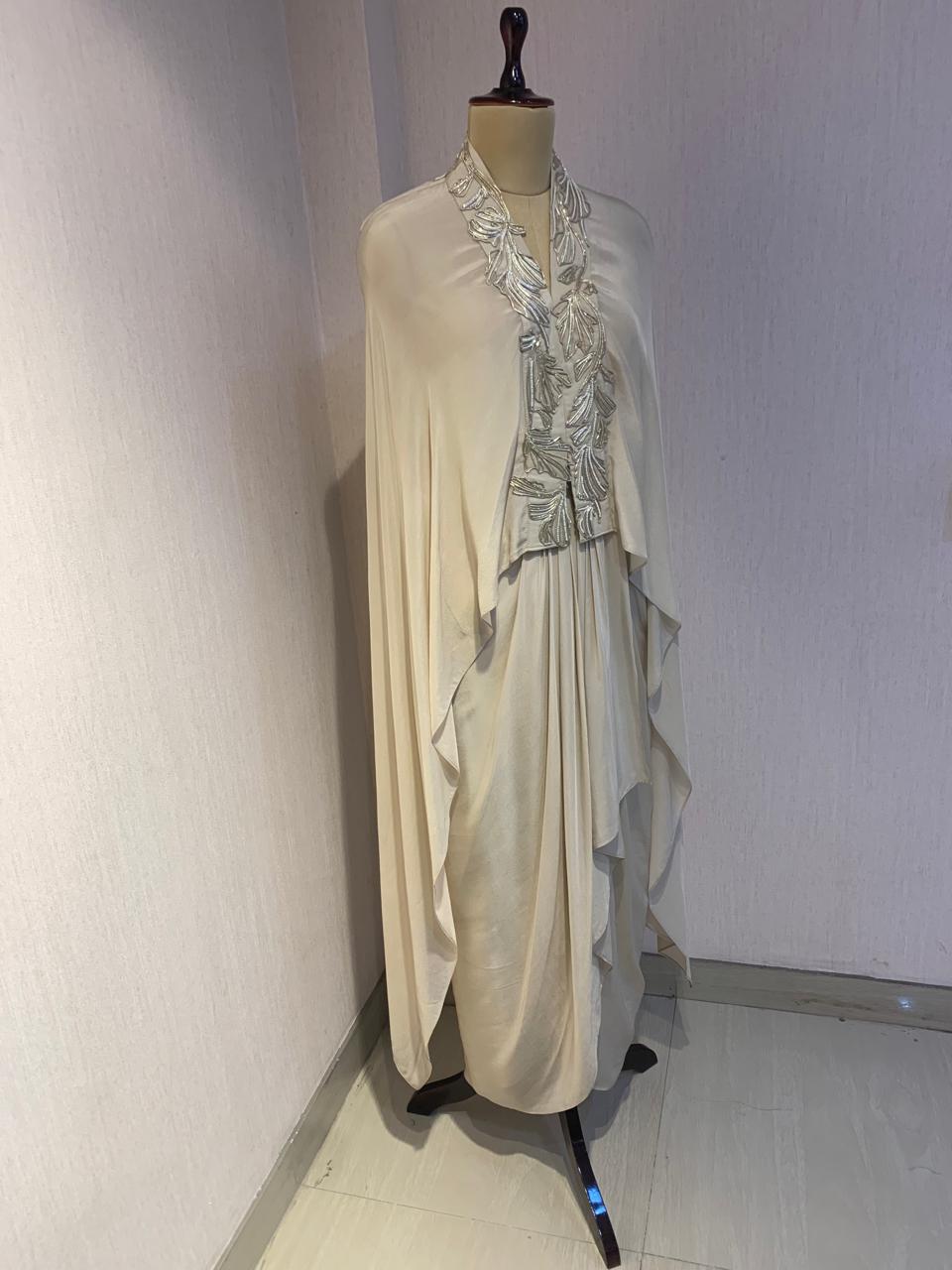 OFF WHITE EMBELLISHED CAPE WITH DRAPED SKIRT.