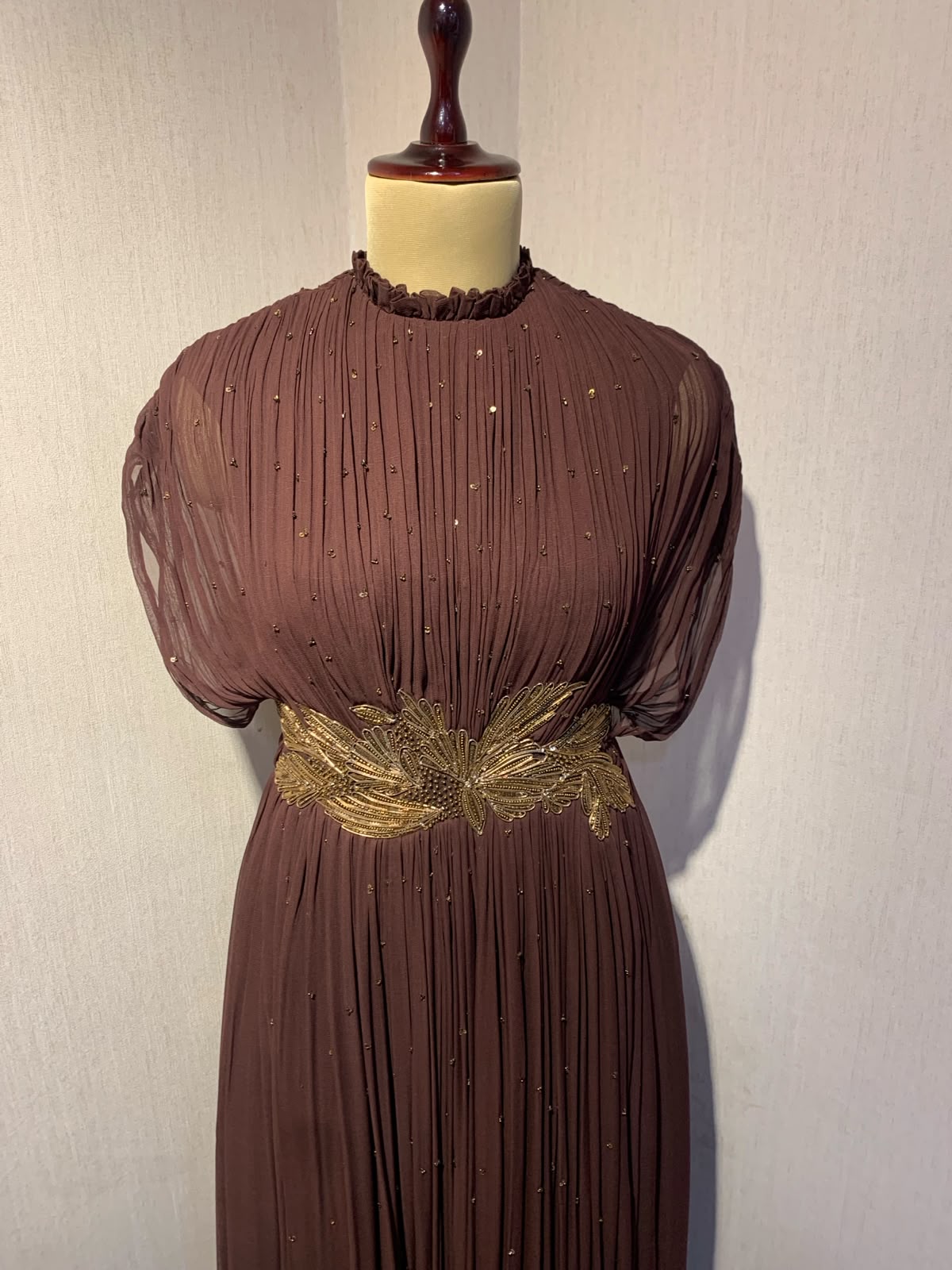BROWN  WIRE EMBELLISHED PLEATED GOWN WITH SHEER SLEEVES.