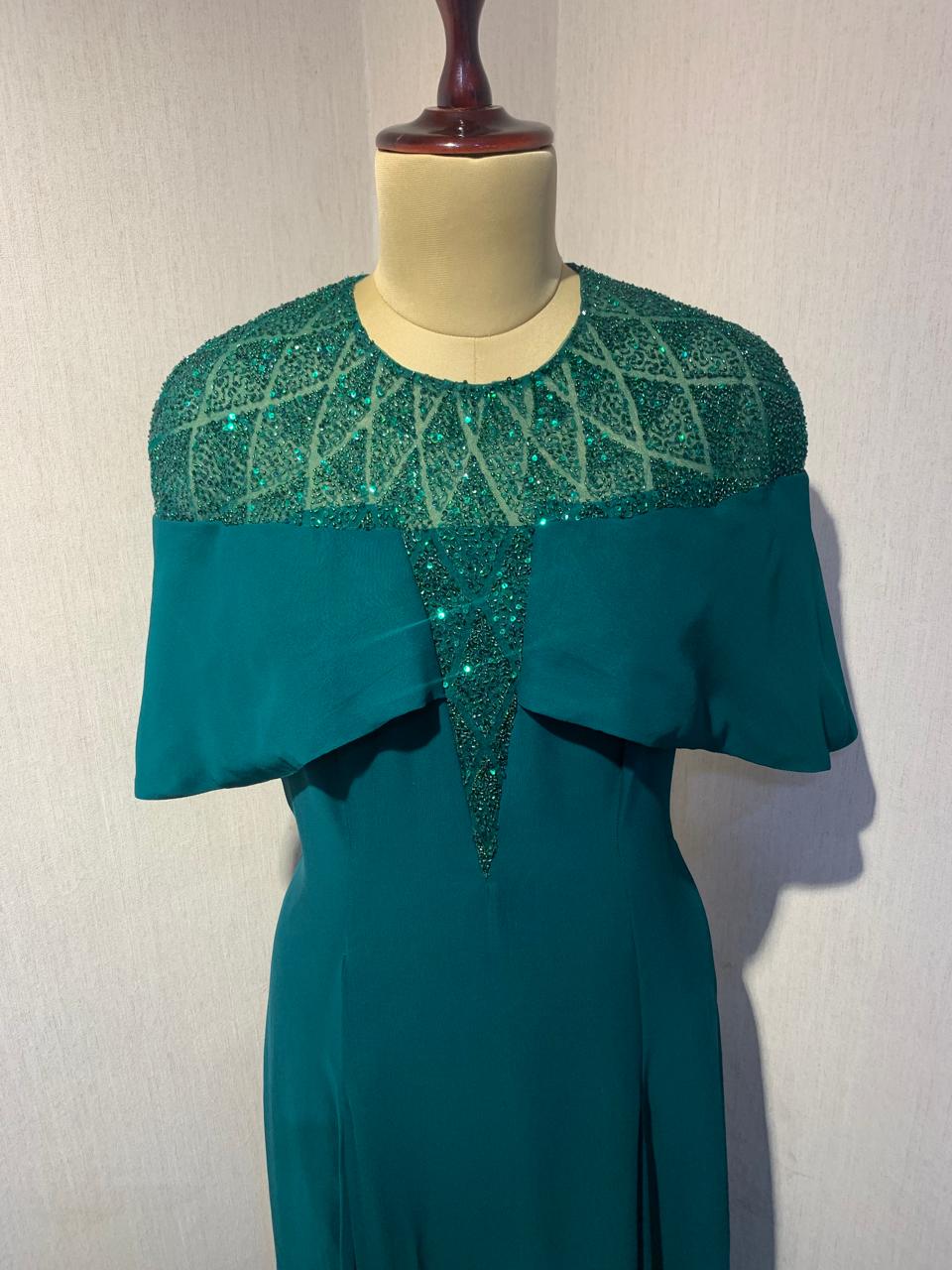 GREEN SEQUIN AND BEAD EMBELLISHED GOWN WITH SHEER NECKLINE.