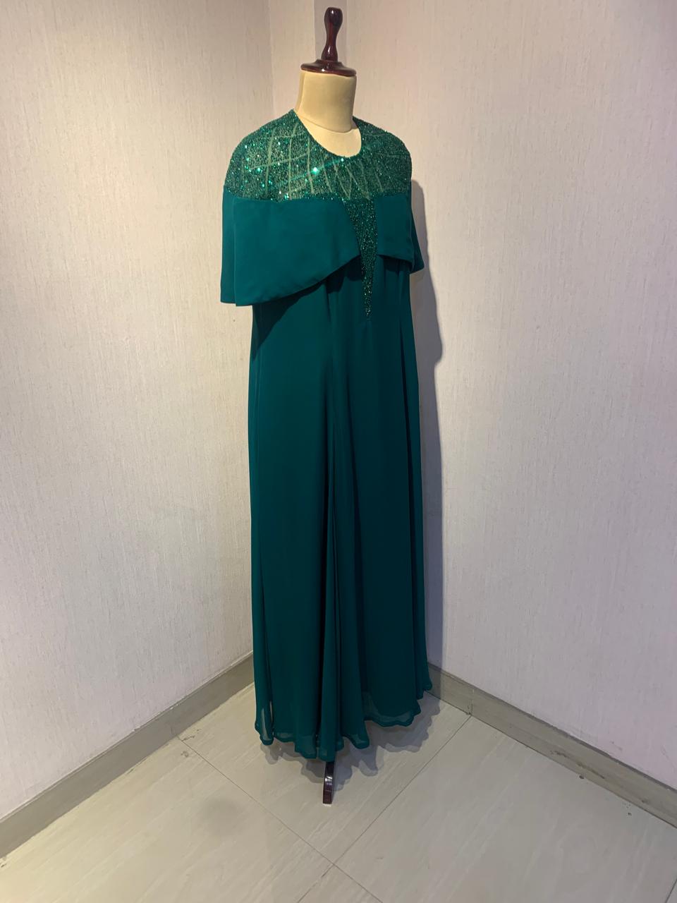 GREEN SEQUIN AND BEAD EMBELLISHED GOWN WITH SHEER NECKLINE.