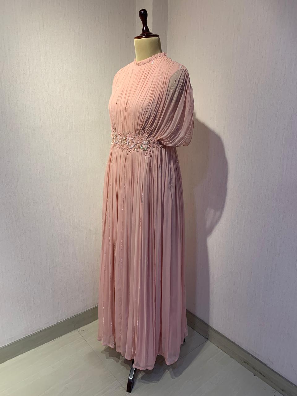 ELEGANT PINK PLEATED GOWN WITH EMBELLISHED WAIST.