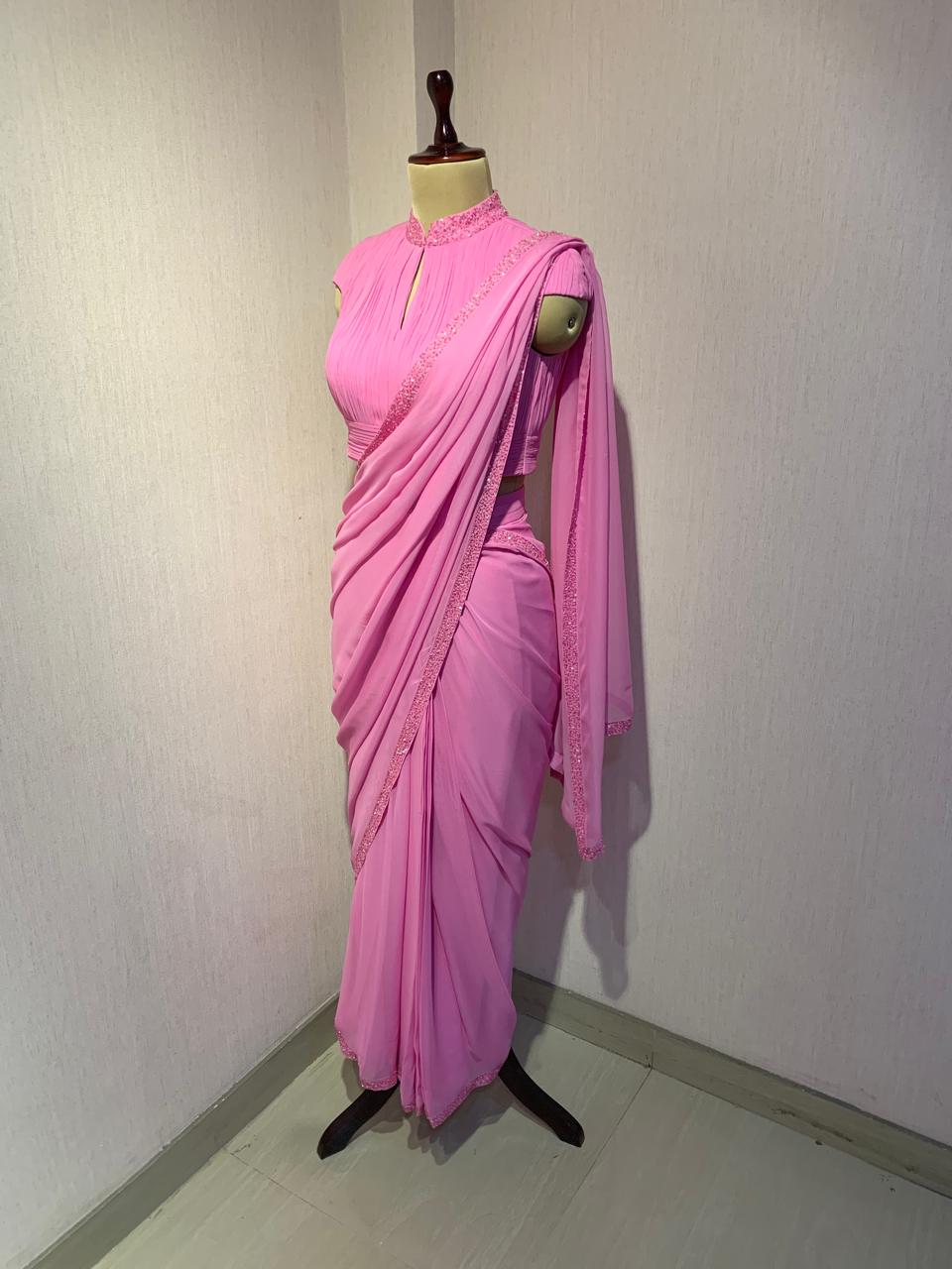 PINK GEORGETTE DRAPED SAREE WITH PLEATED HIGH NECK BLOUSE.